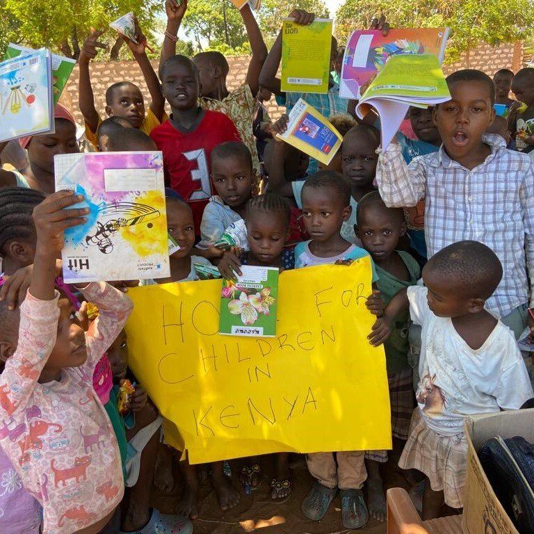 Eine Gruppe von Kindern hält ein Schild mit der Aufschrift „Heim für Kinder in Kenia“