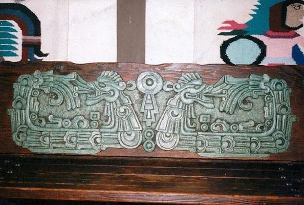 A wooden plaque with a green design on it