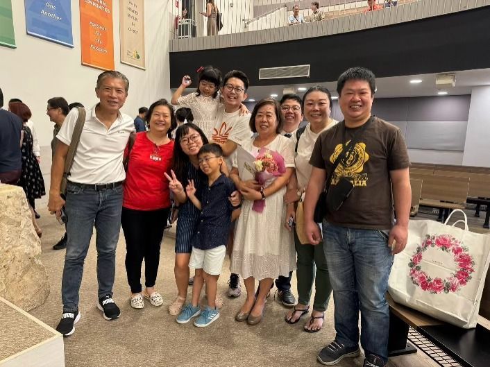A joyful baptism for Jesmond (3rd from right) and his mother, surrounded by family.