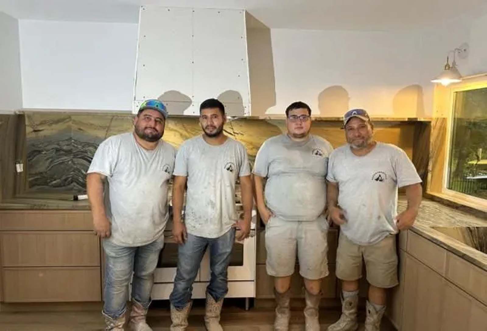 A group of men are standing next to each other in a kitchen.