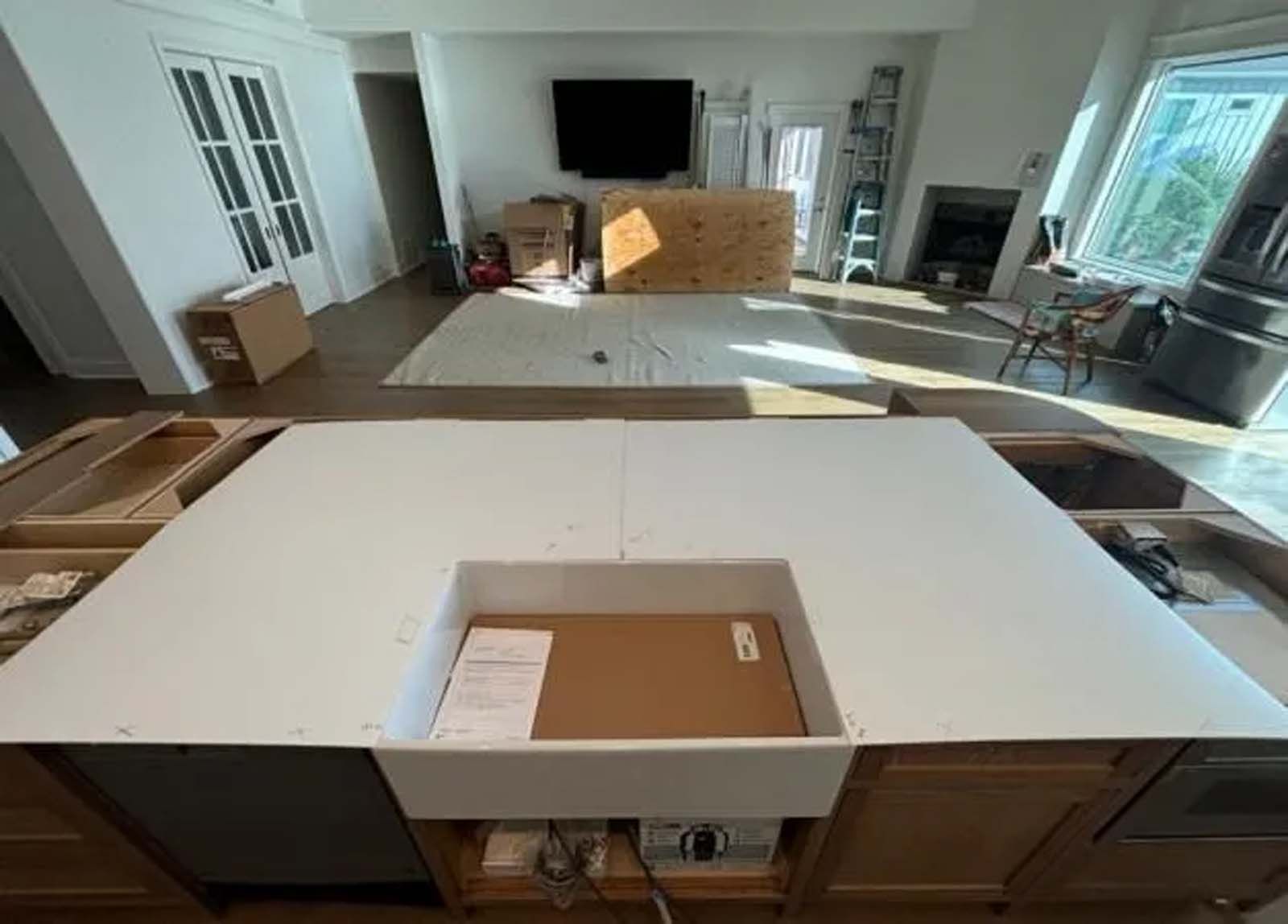 A kitchen is being remodeled and a sink is being installed.