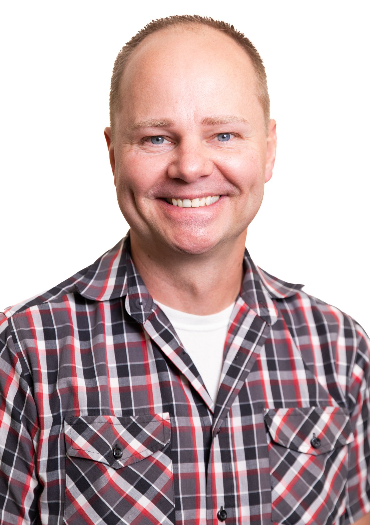 A man in a plaid shirt is smiling for the camera.