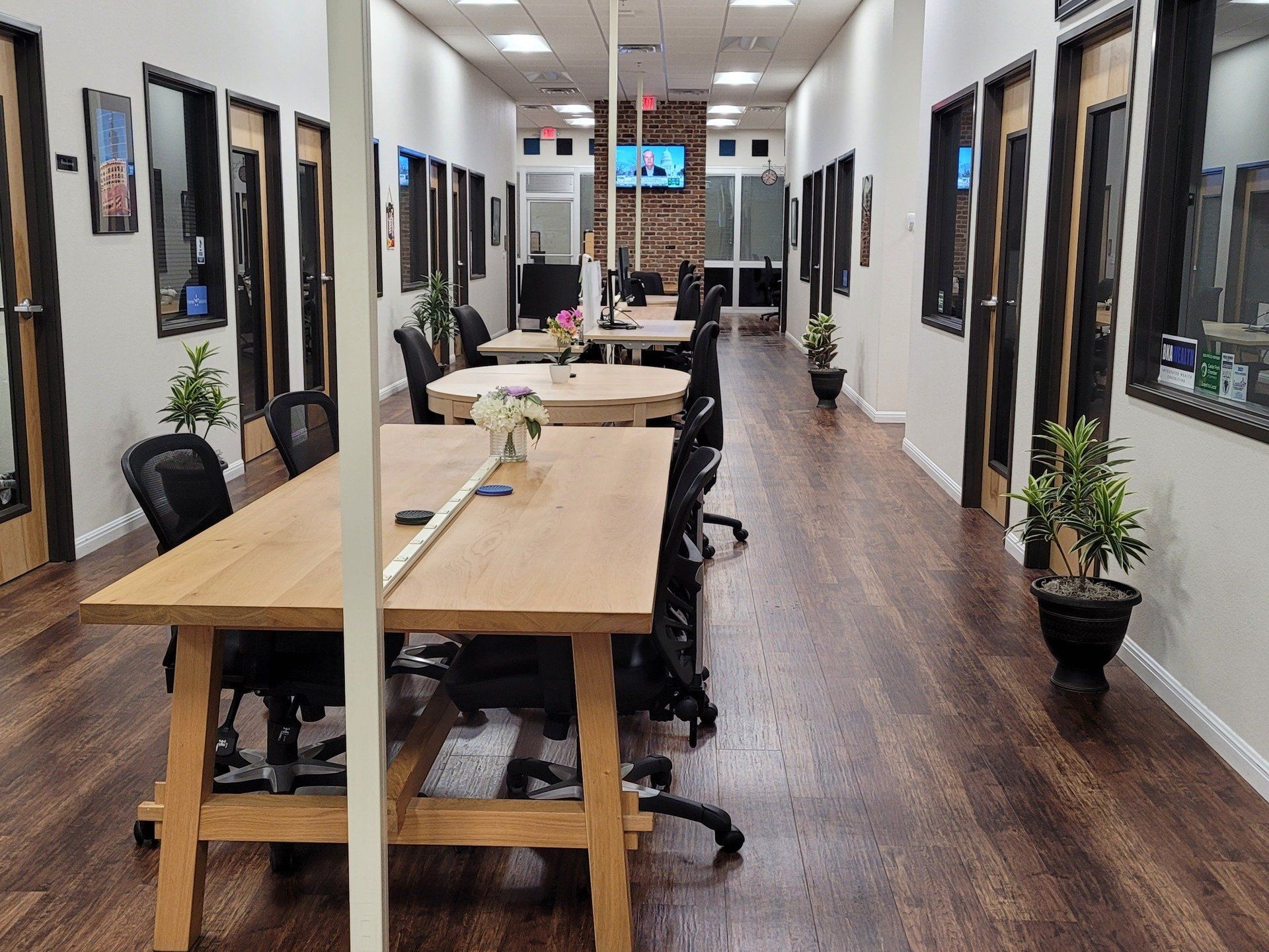 A long hallway with tables and chairs in an office.
