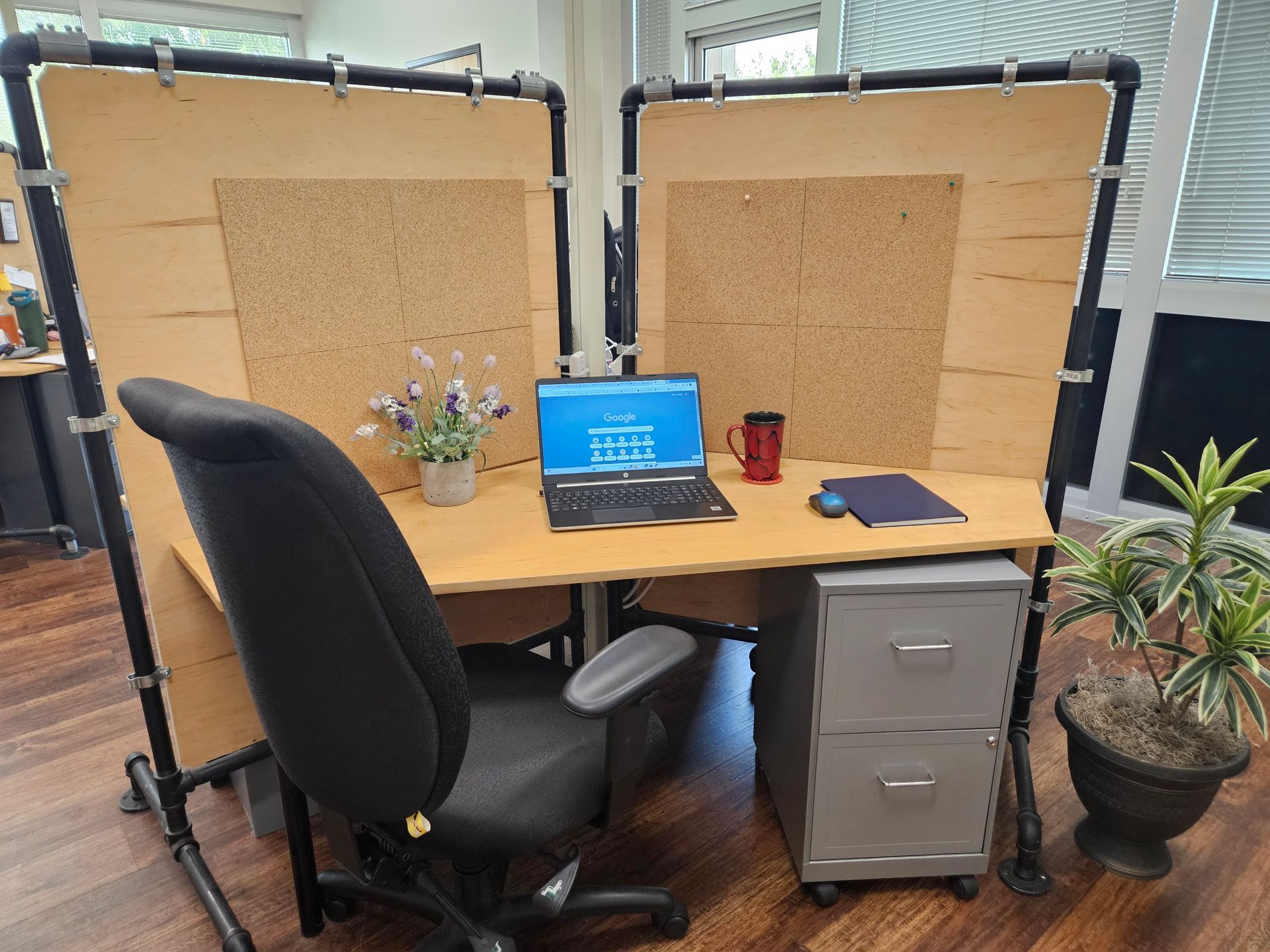 A laptop computer is sitting on a desk next to a chair.