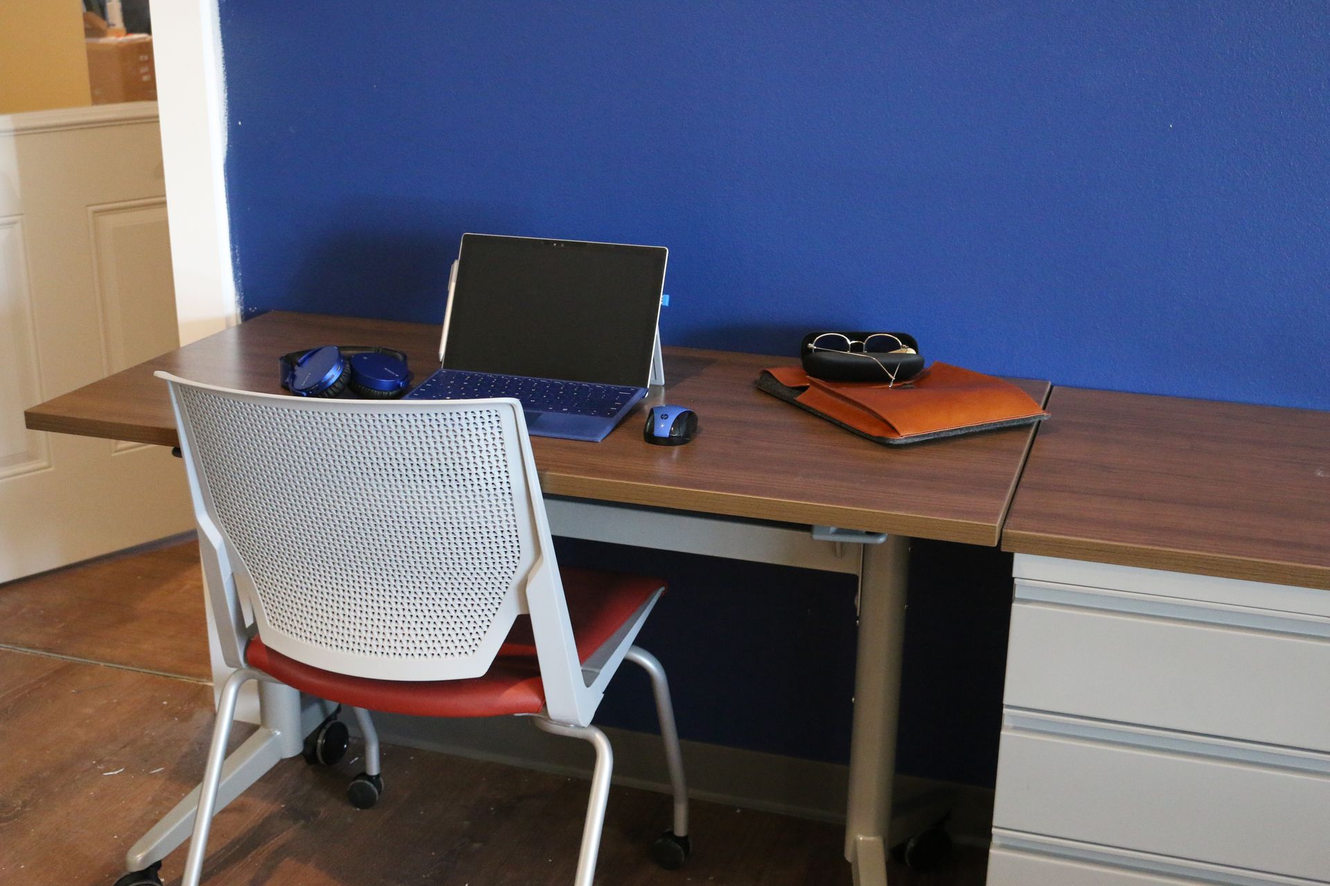 A desk with a chair and a laptop on it