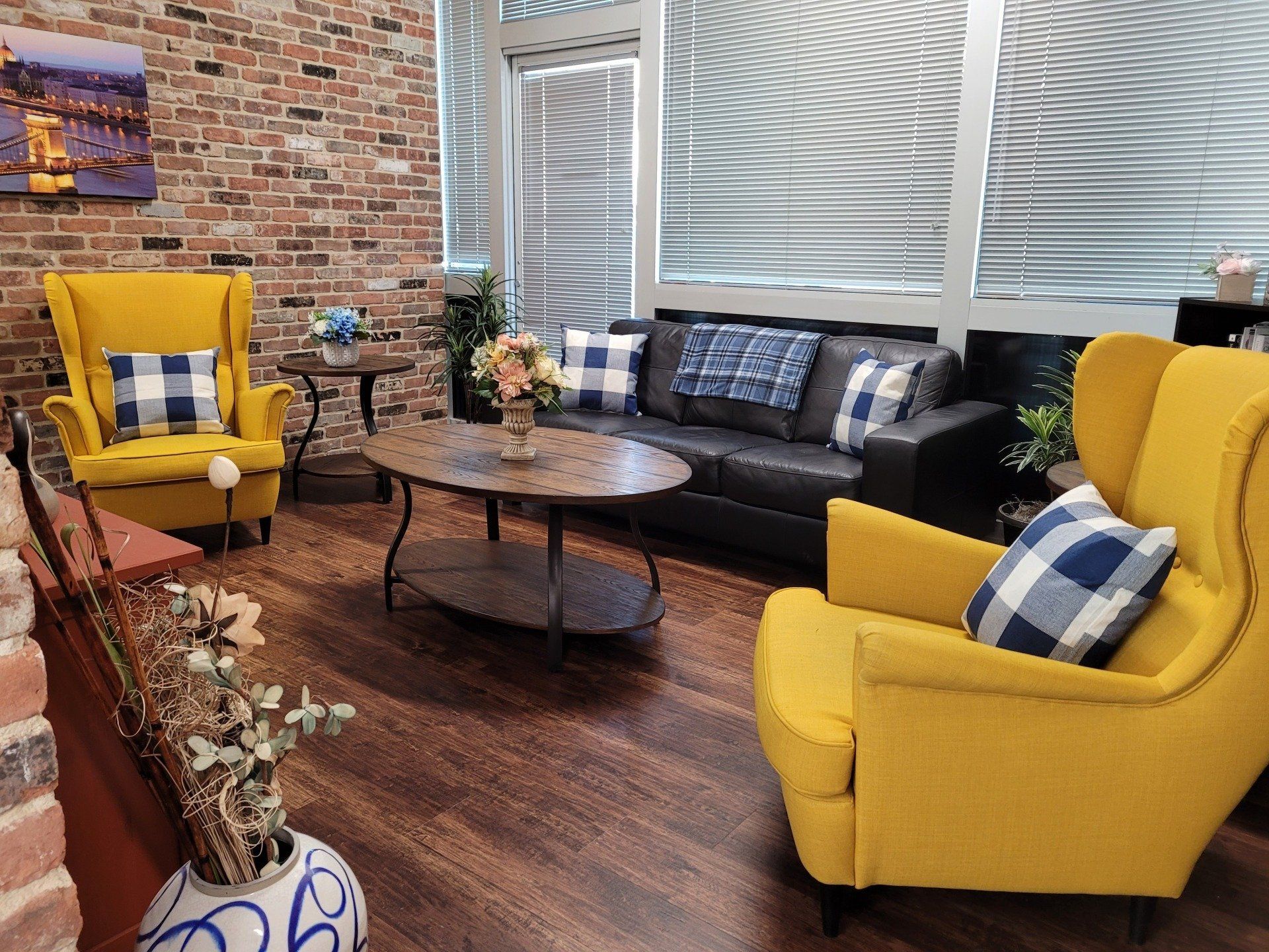 A living room with yellow chairs , a couch , and a coffee table.