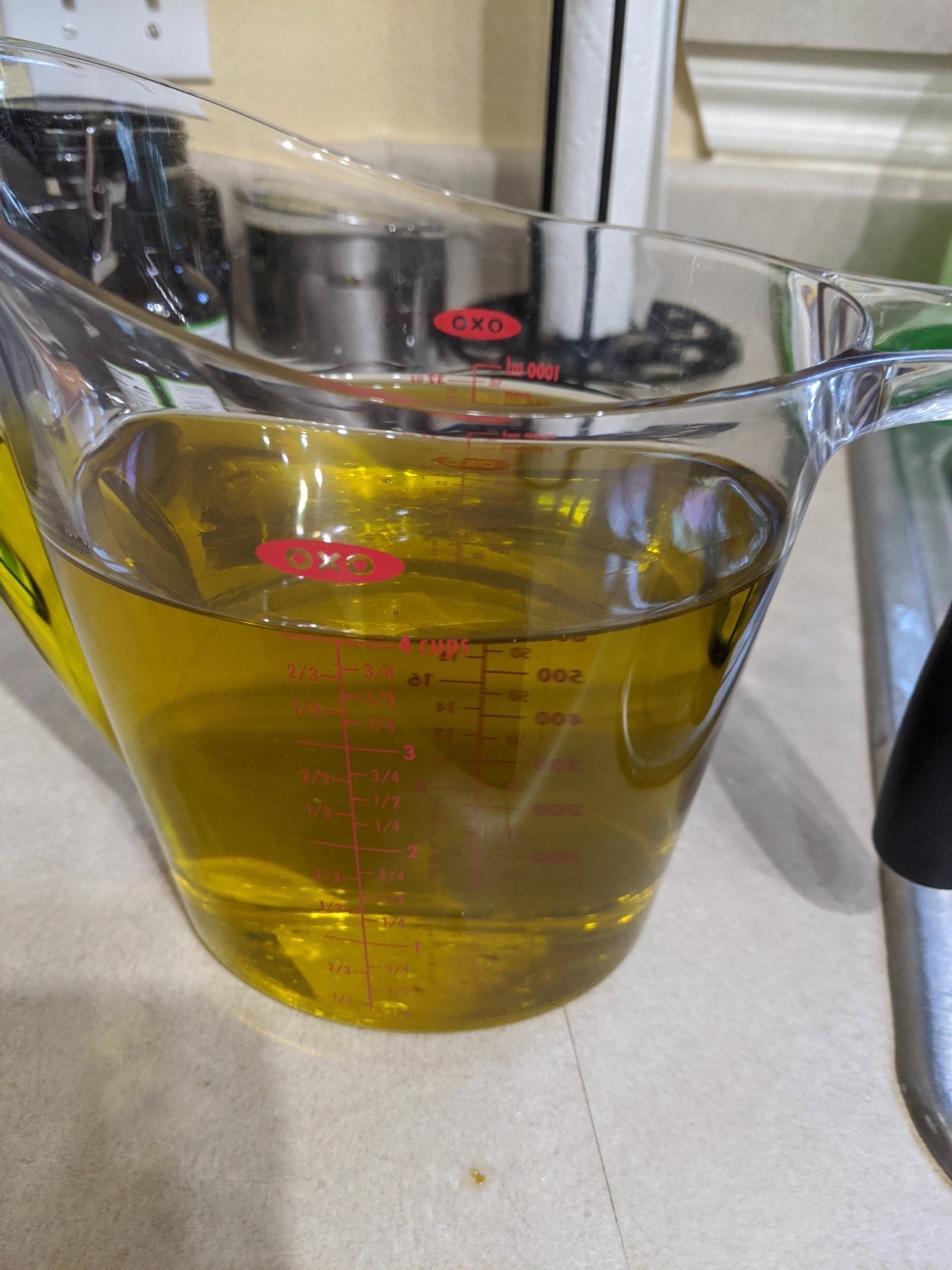 A measuring cup filled with liquid is sitting on a counter.