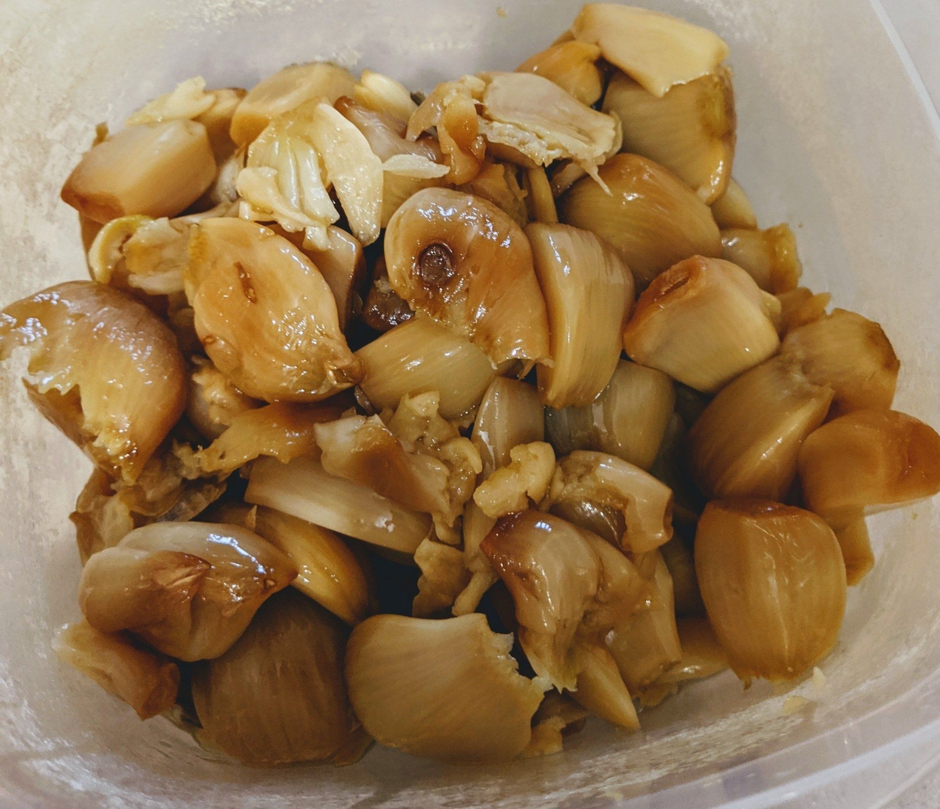 A close up of a plastic container filled with fried garlic