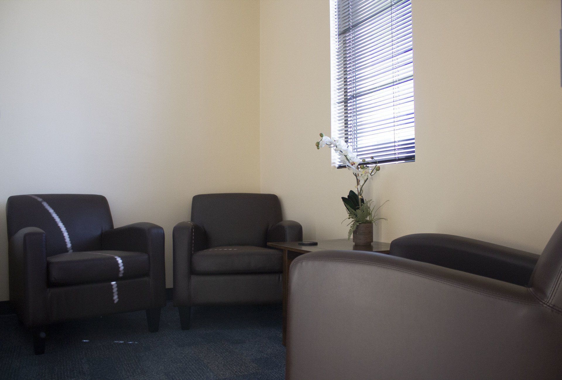 A room with two chairs and a window with blinds
