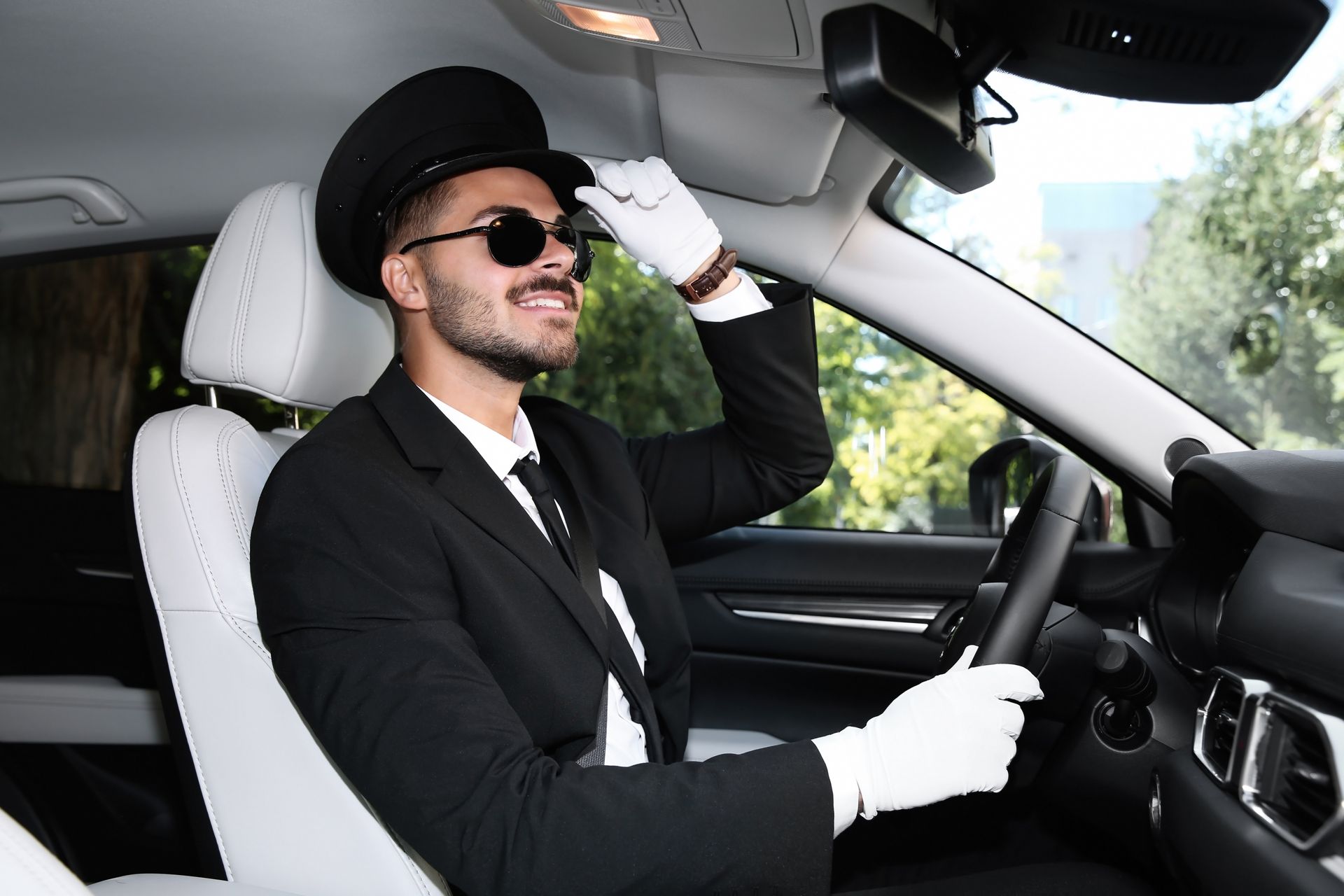 A man in a suit and tie is driving a car.