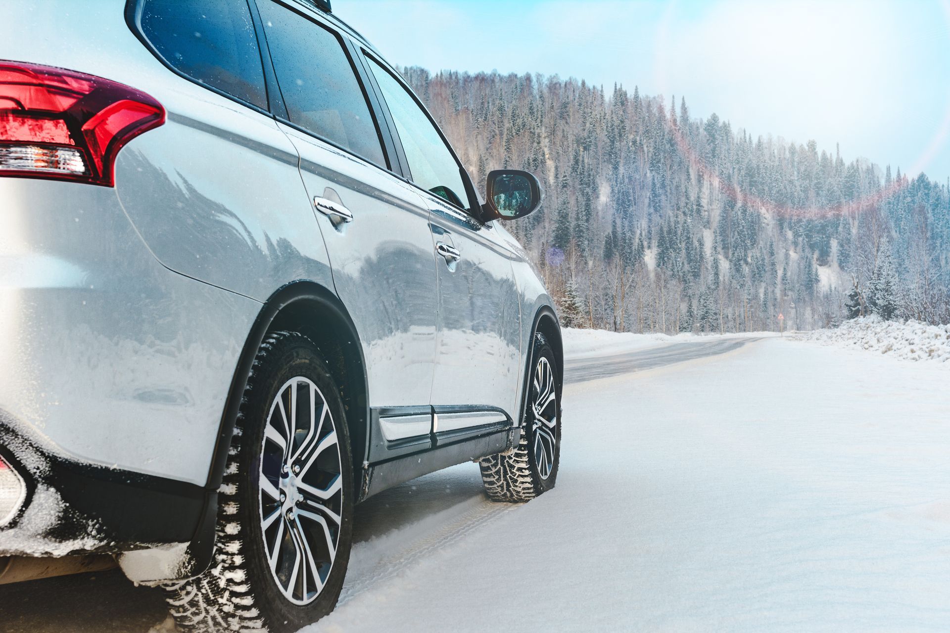 A car is parked on the side of a snow covered road.