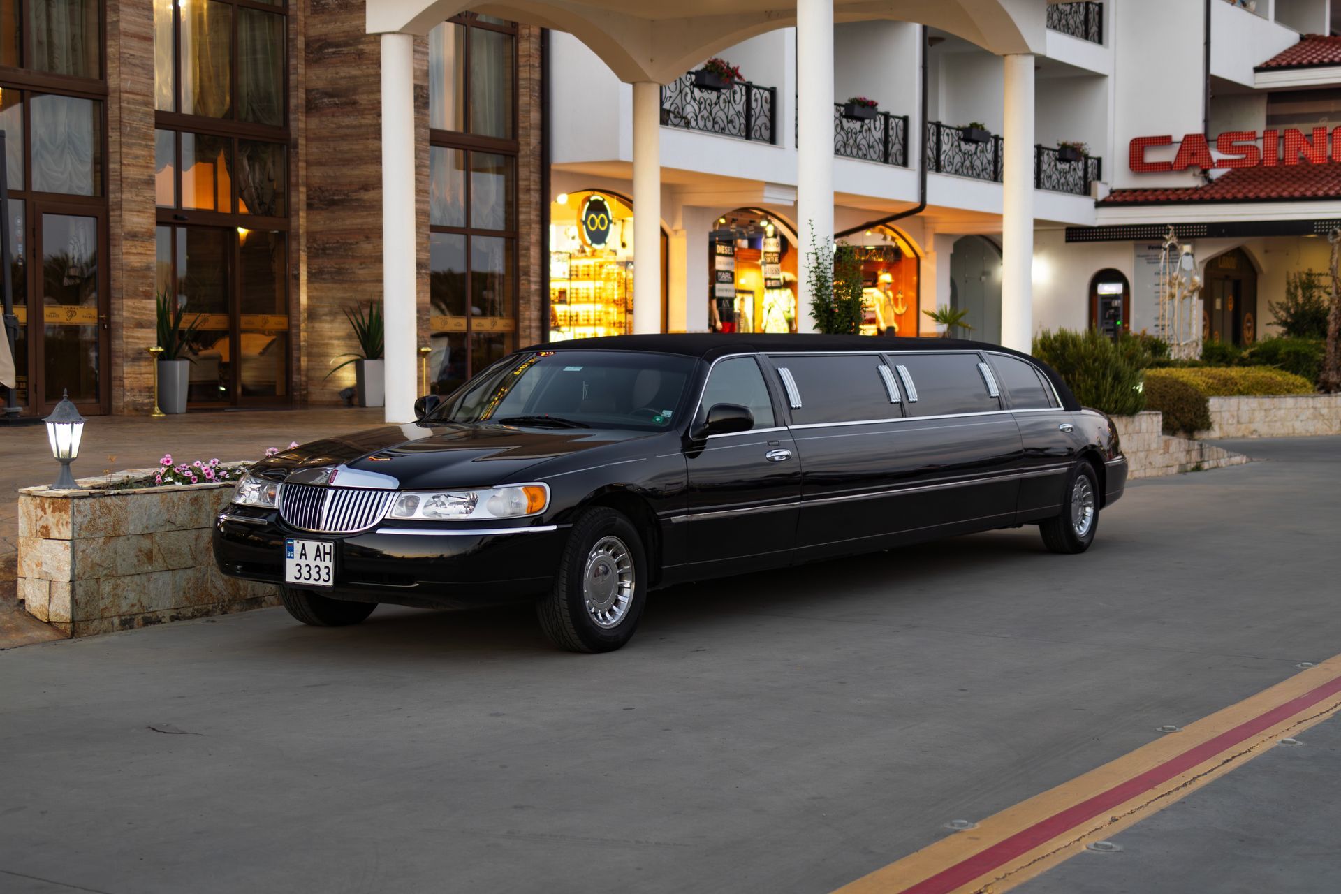 A black limousine is parked in front of a building