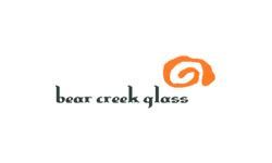 A bear creek glass logo with an orange swirl on a white background.
