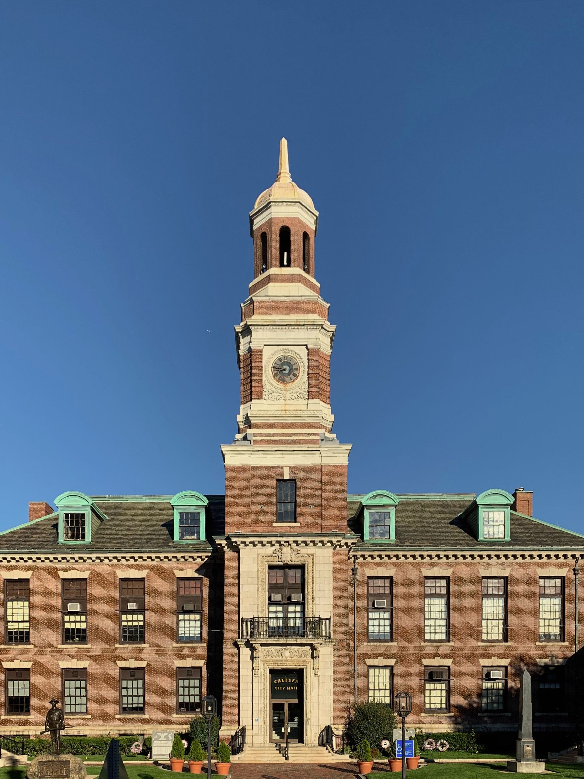 A man and woman are holding a child in their arms in a park.