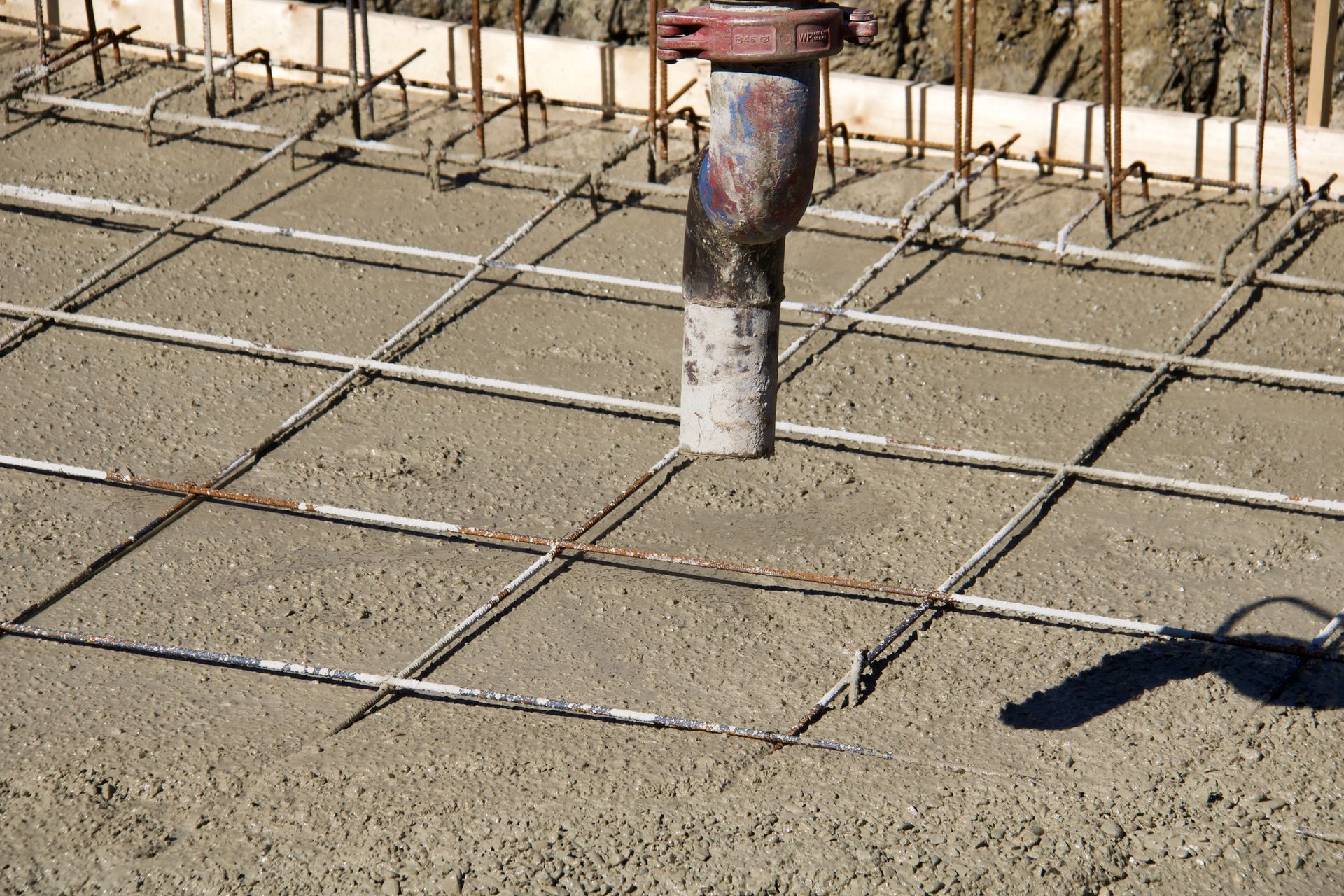 Final part of concrete mixer arm with pump on bottom of residence under construction. Final part of concrete mixer arm with pump on bottom of residence under construction.