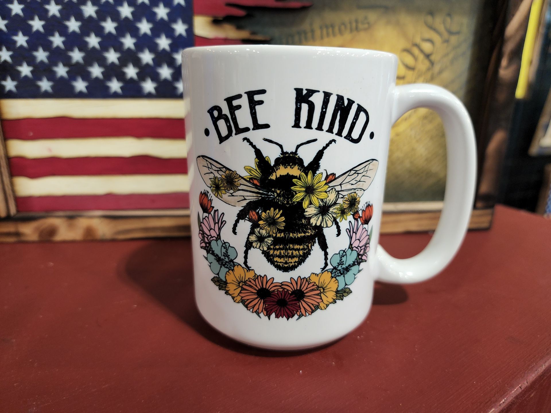 A coffee mug with a bee on it that says bee kind