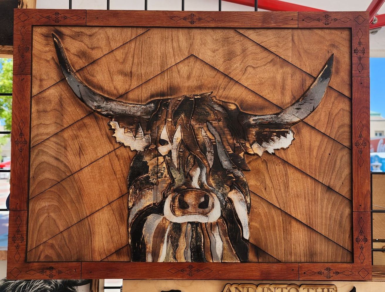 A painting of a bull 's head in a wooden frame