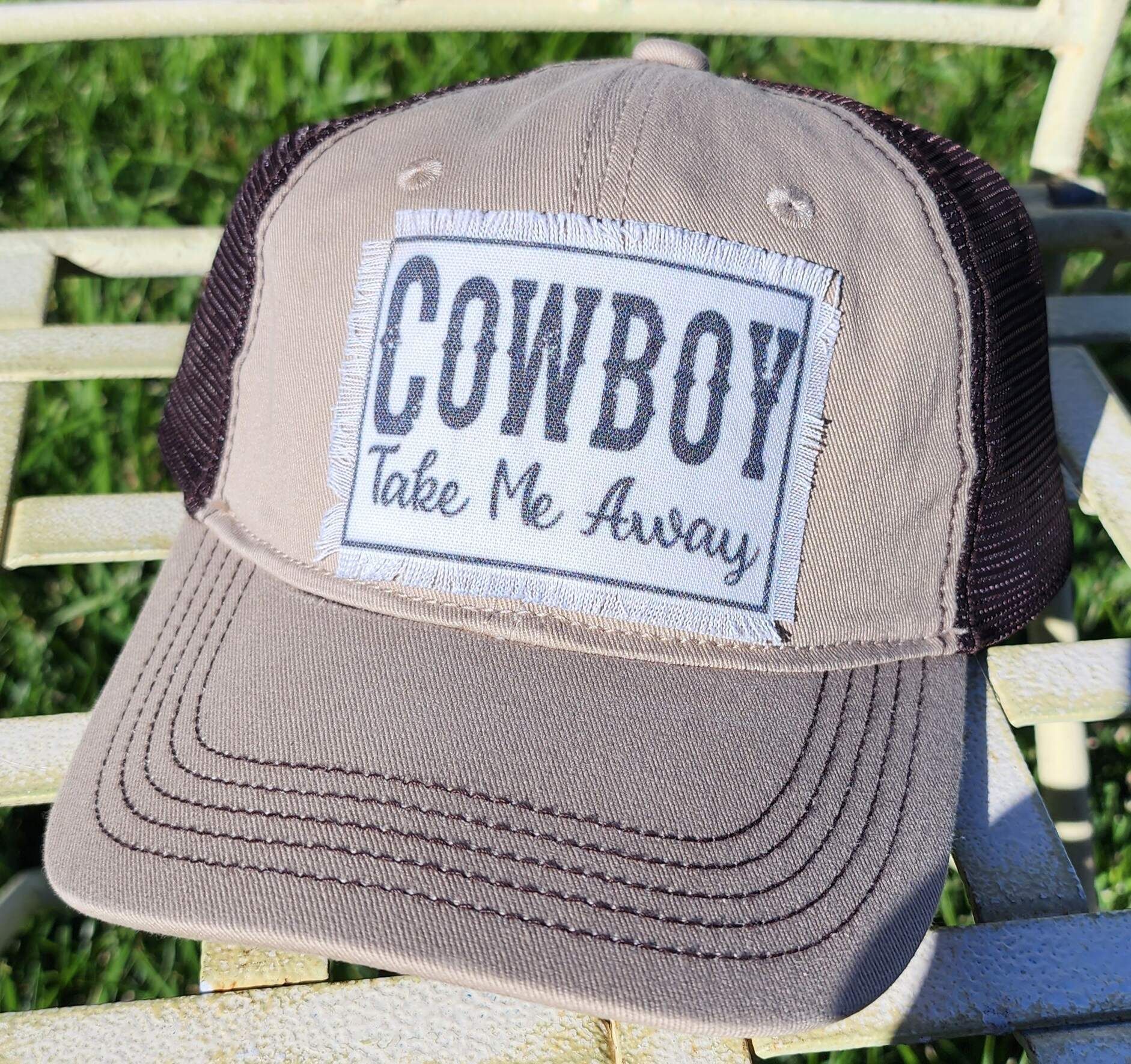 A baseball cap that says `` cowboy take me away '' is sitting on a chair.