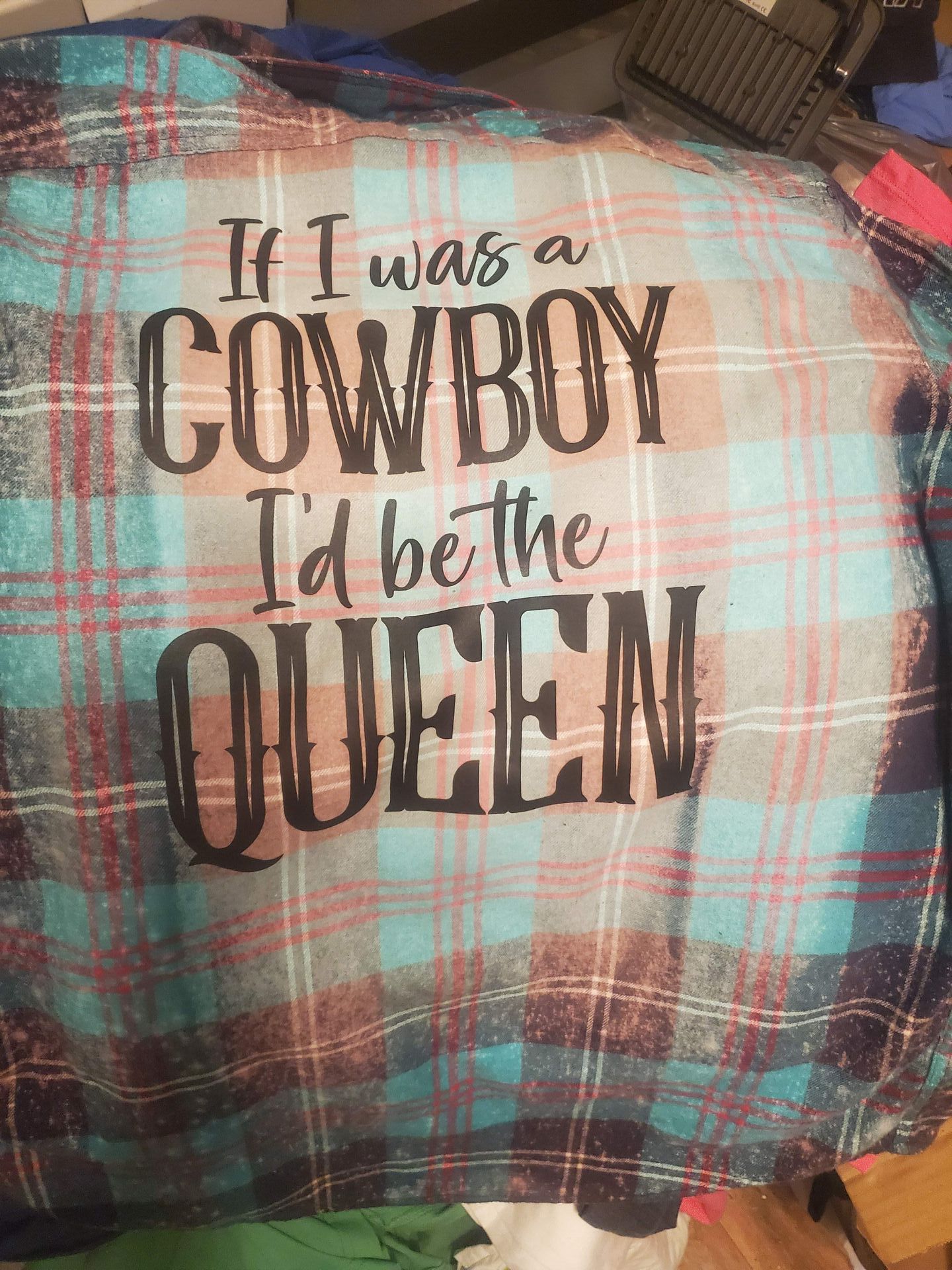 A plaid shirt that says `` if i was a cowboy i 'd be the queen ''.