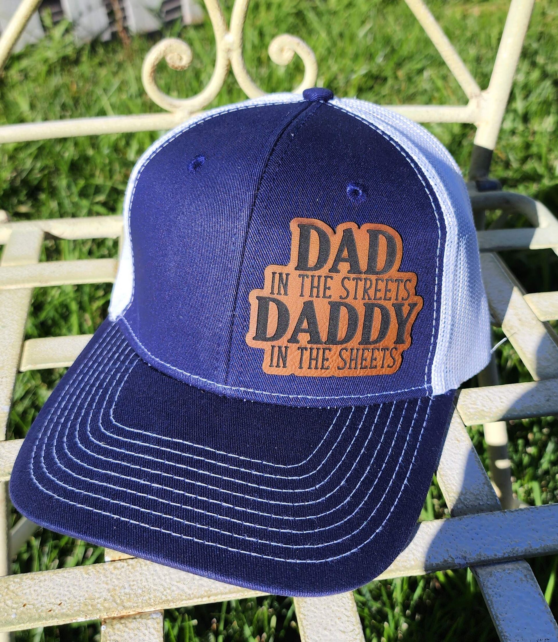 A baseball cap that says `` dad in the street daddy in the streets '' is sitting on a chair.