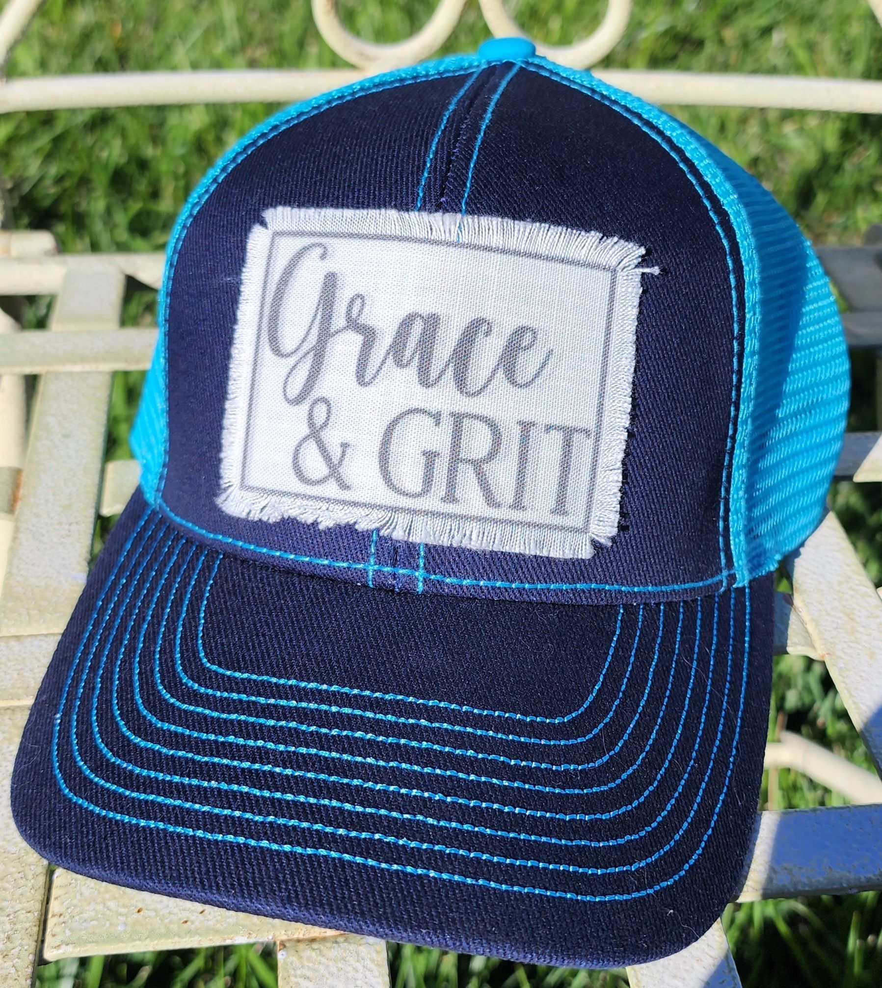 A baseball cap with a patch that says grace and grit