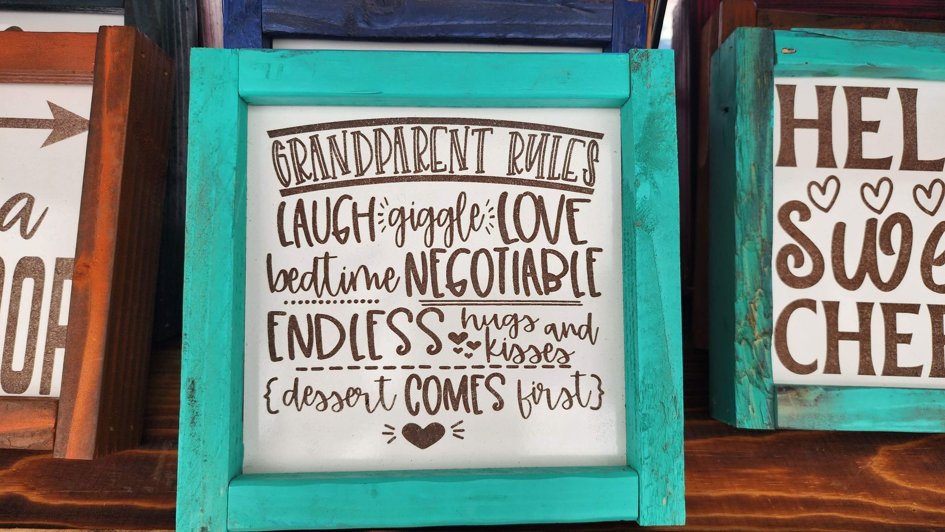 A turquoise frame with a white sign that says `` grandparents are laugh - giggle - love bedtime negotiable ''
