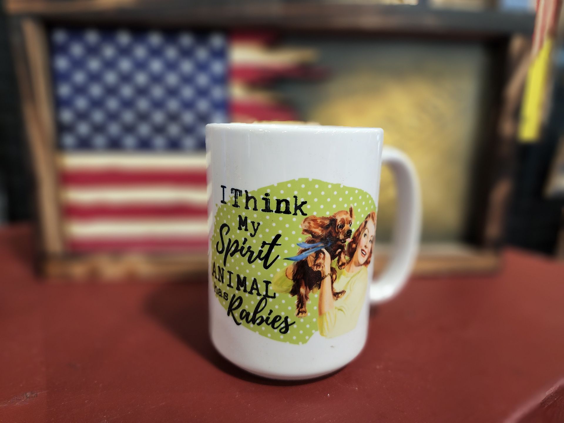 A mug that says `` i think my spirit animal rabies '' is sitting on a table.