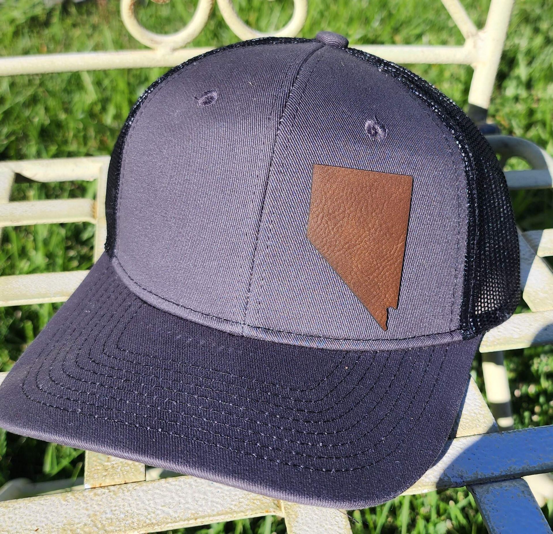 A baseball cap is sitting on a bench in the grass
