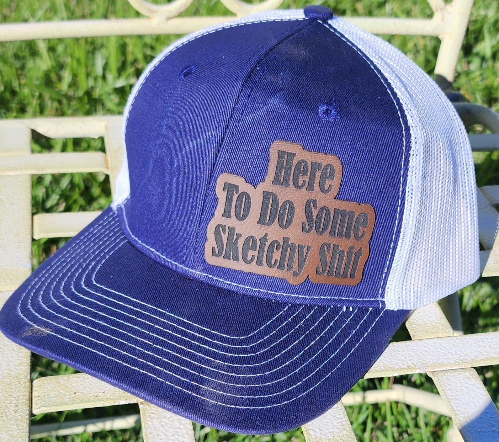 A blue and white hat that says here to do some sketchy stuff