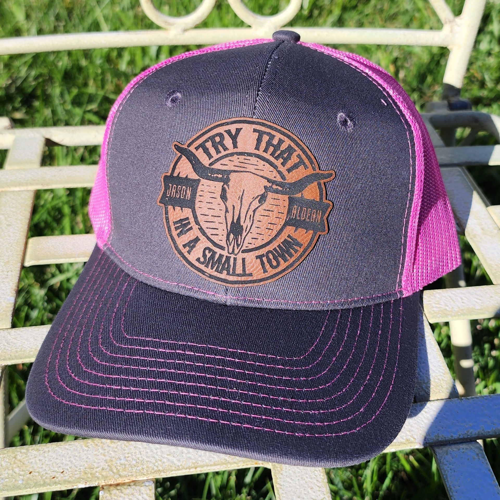 A baseball cap with a cow skull on it is sitting on a chair.