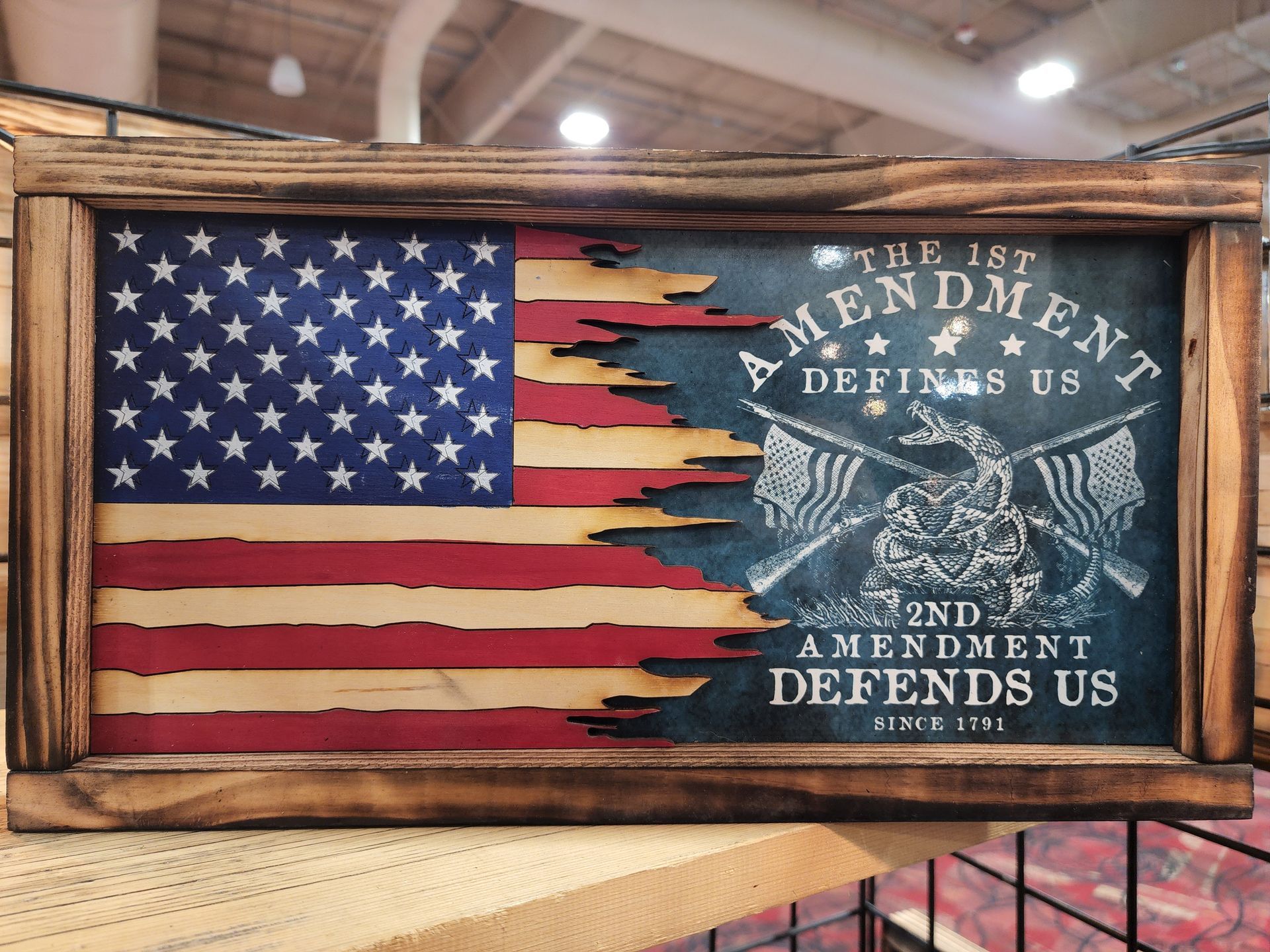 A wooden american flag with the words `` the 2nd amendment defends us '' on it.