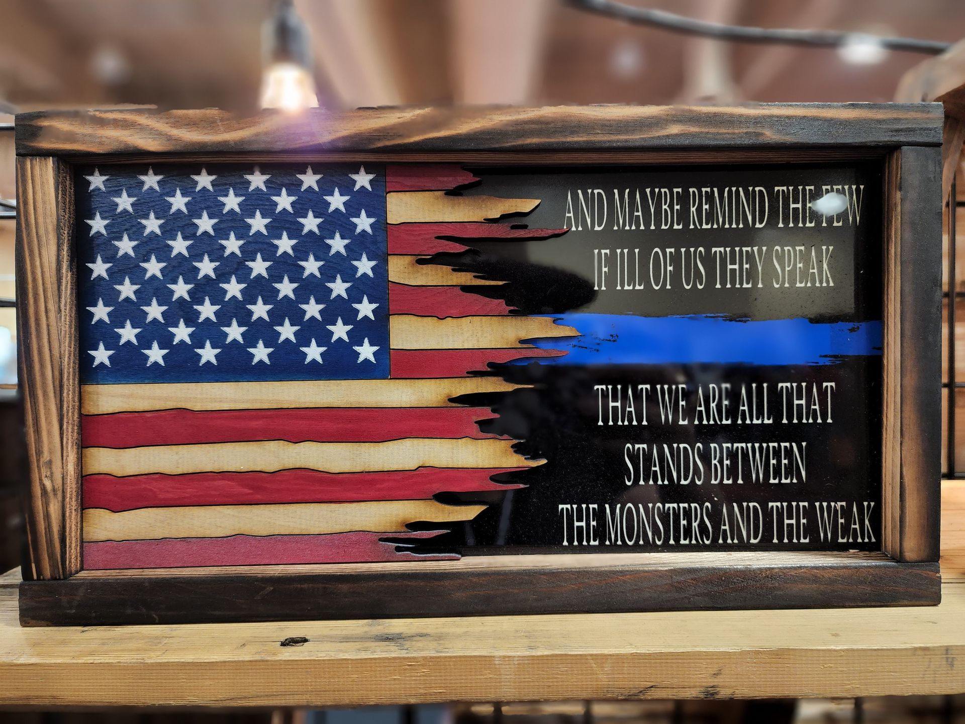 A framed american flag with the words that we are all that stands between the monsters and the weak