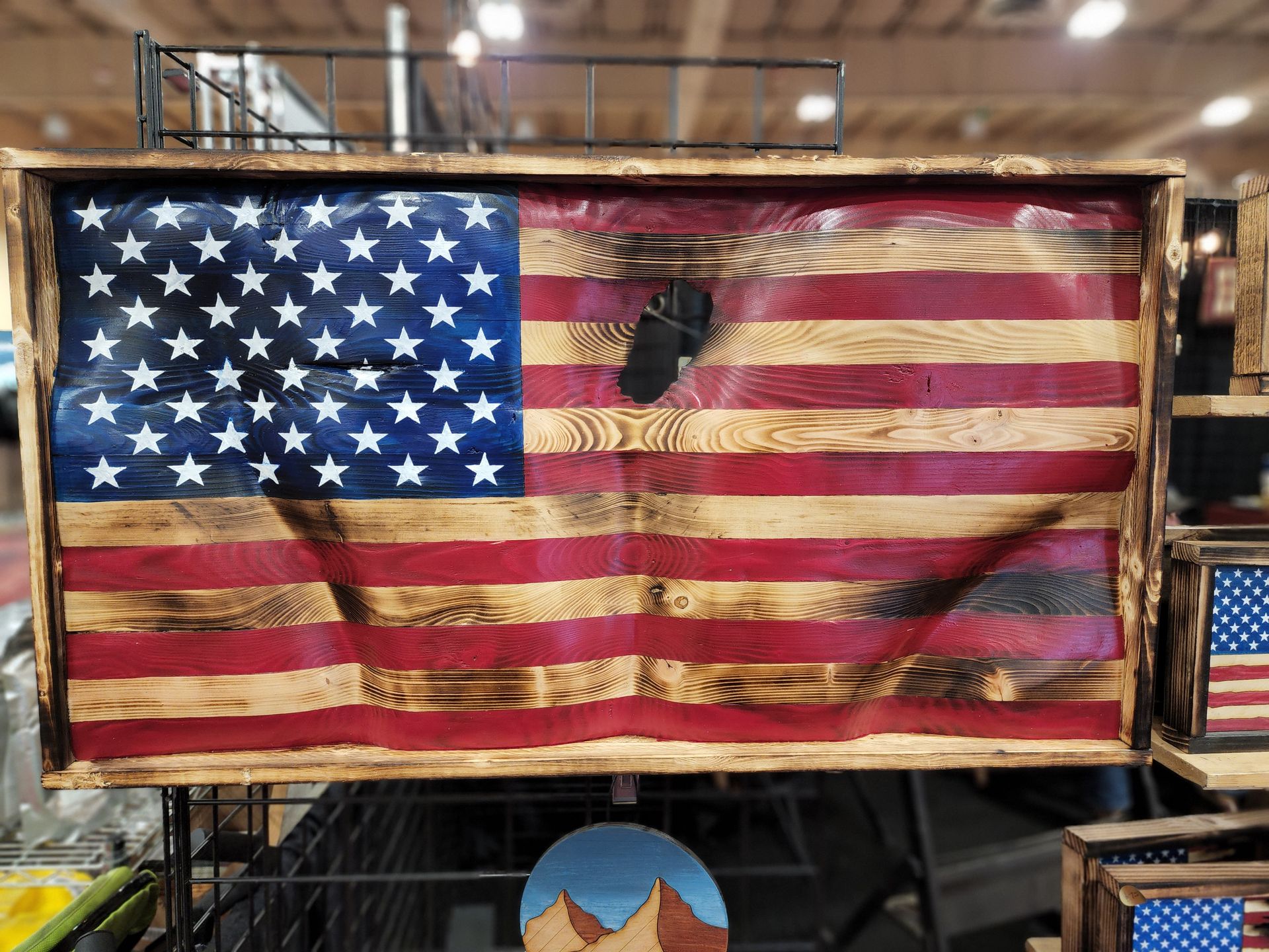 A wooden american flag is hanging on a wall in a store.