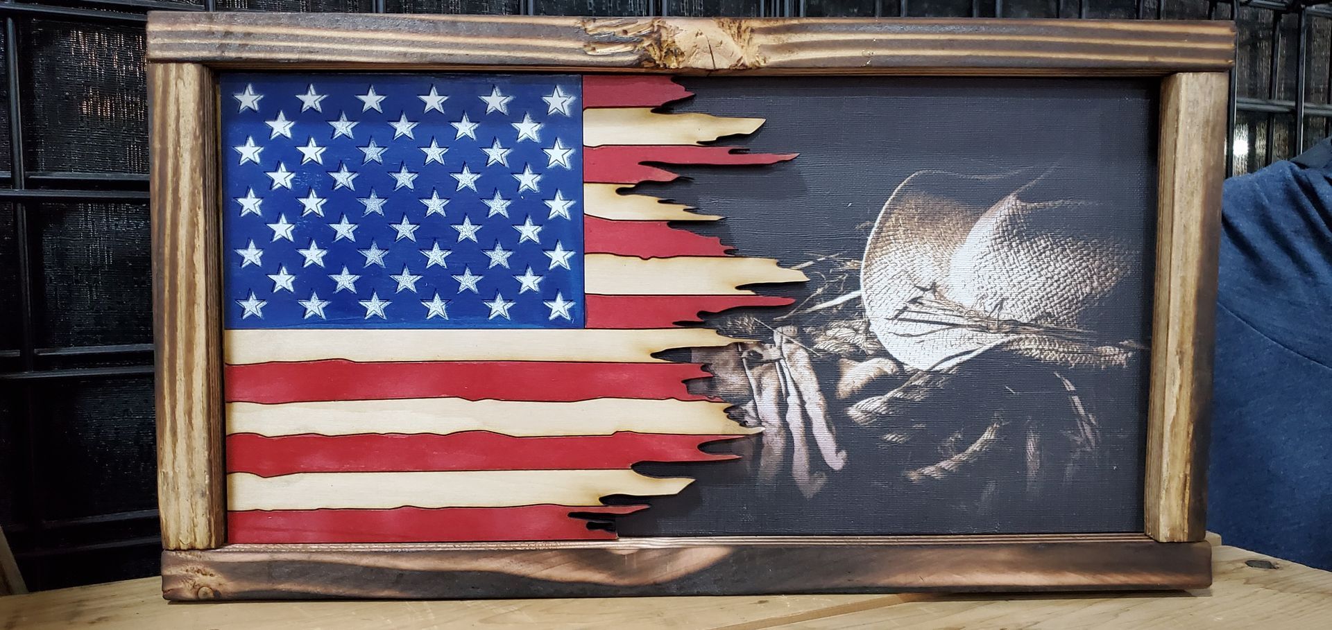 A wooden american flag with a picture of a man on it.
