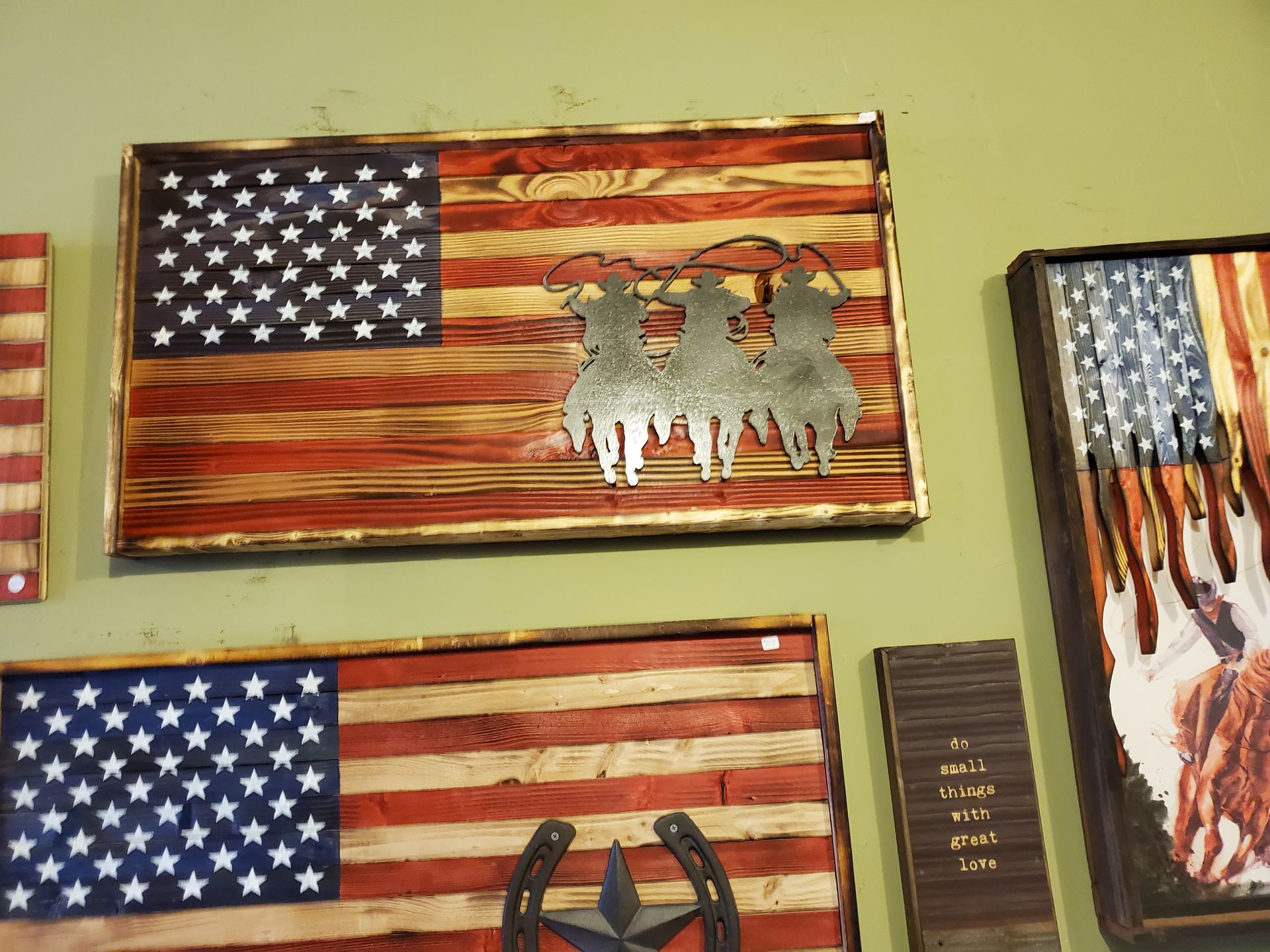 A group of wooden american flags are hanging on a wall.