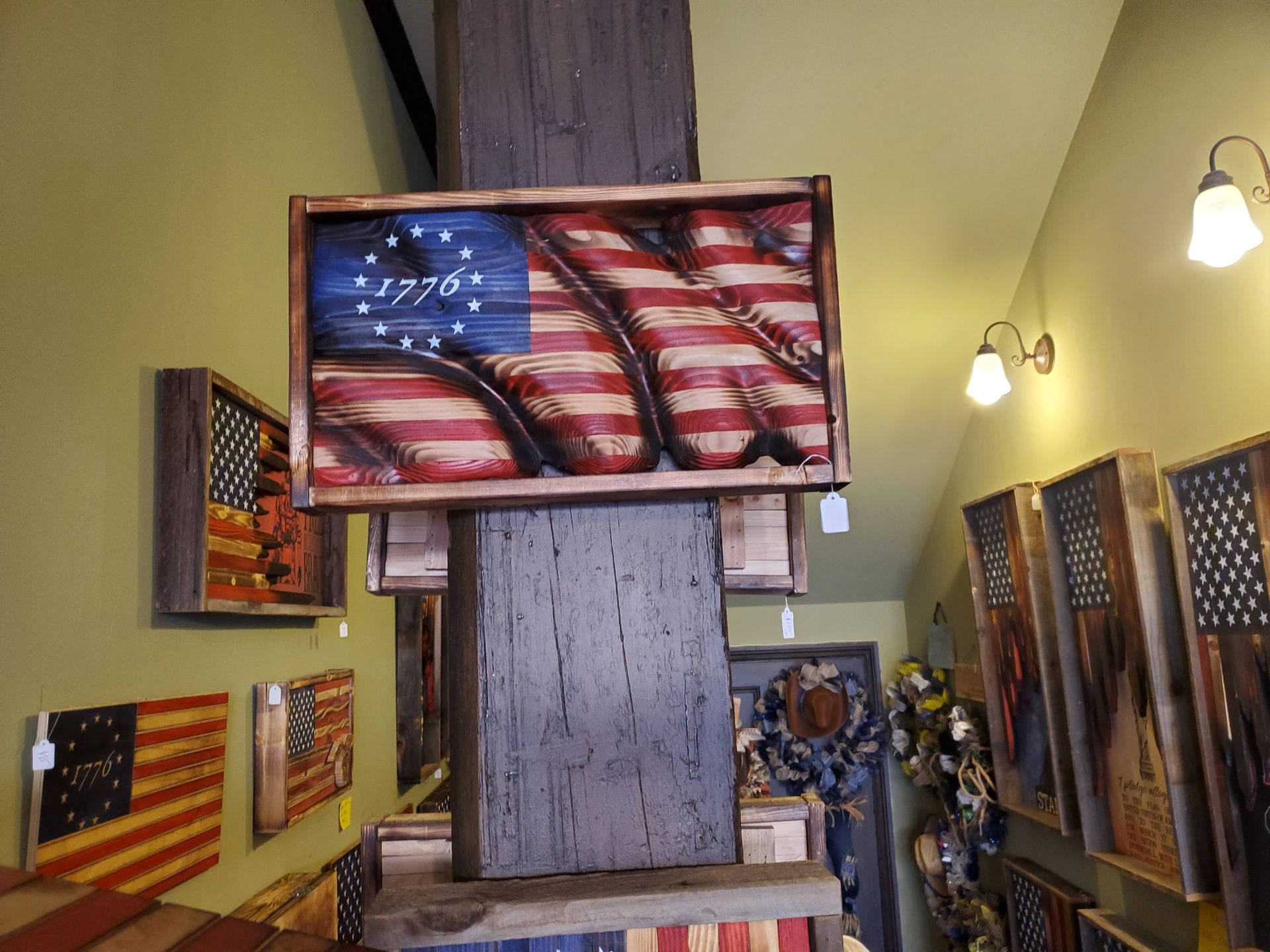 A picture of an american flag is hanging on a wooden pole.