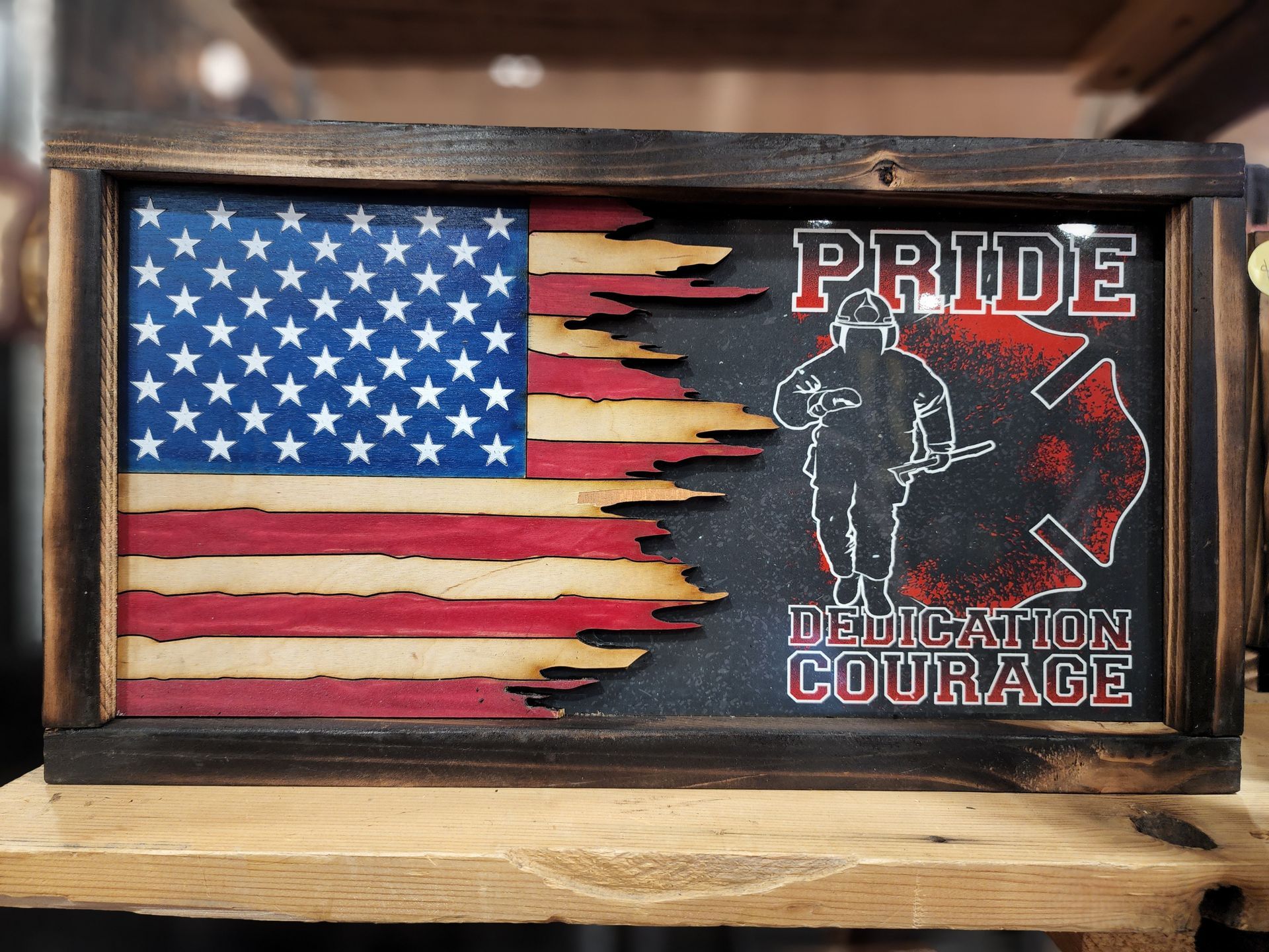 A wooden sign with an american flag and a fireman on it.