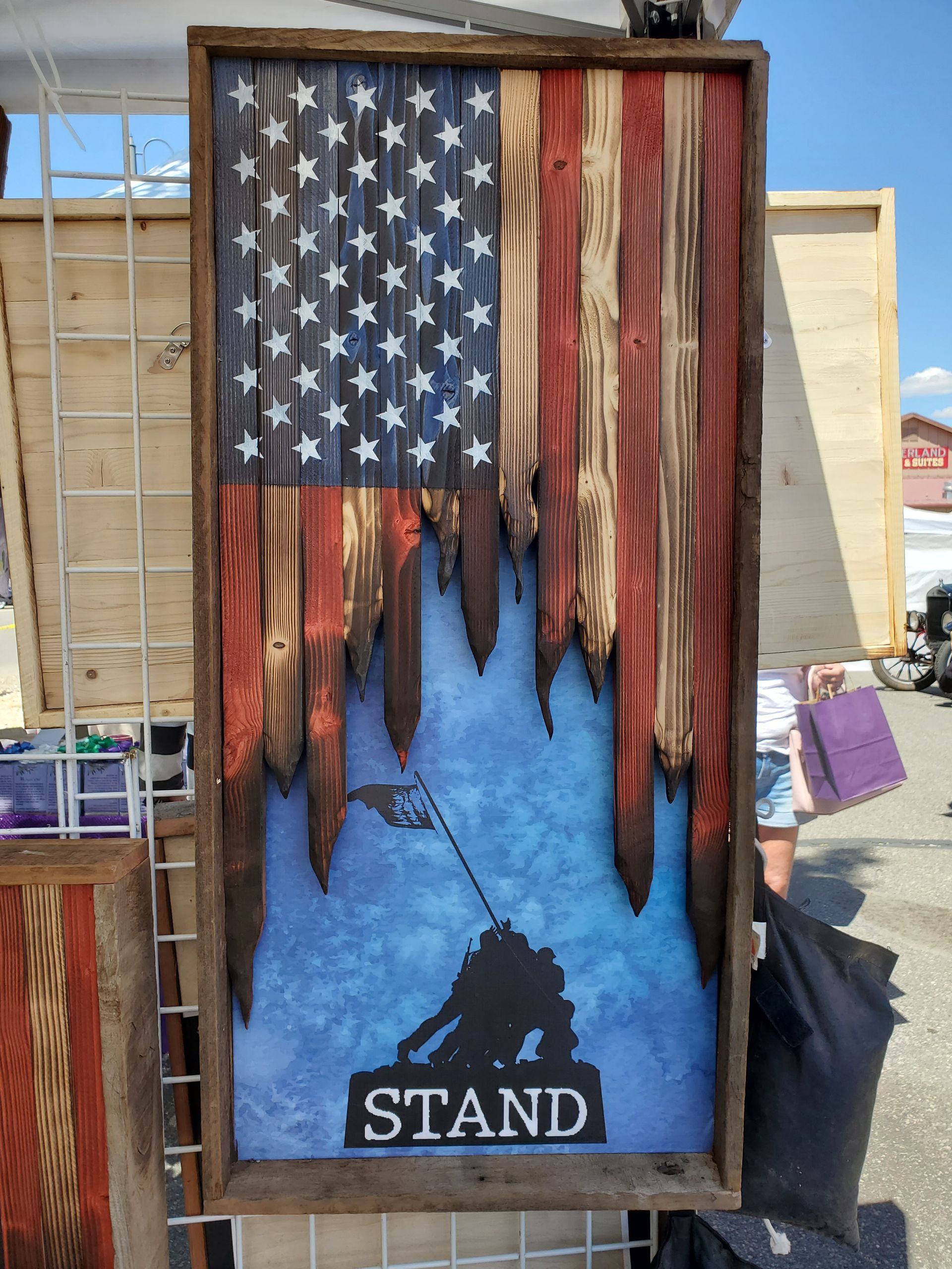 A wooden american flag with the word stand on it