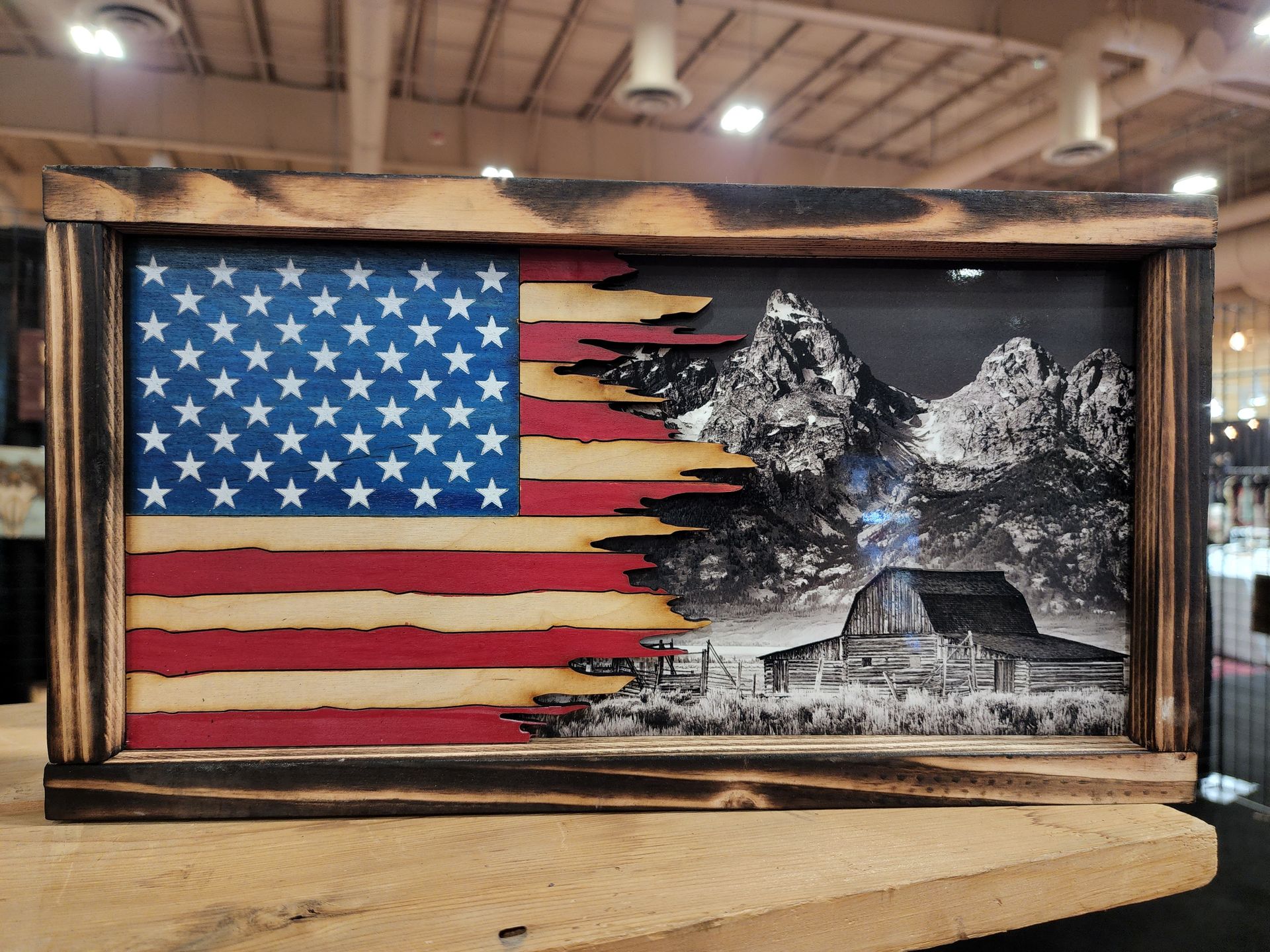 A picture of an american flag with a barn in the background