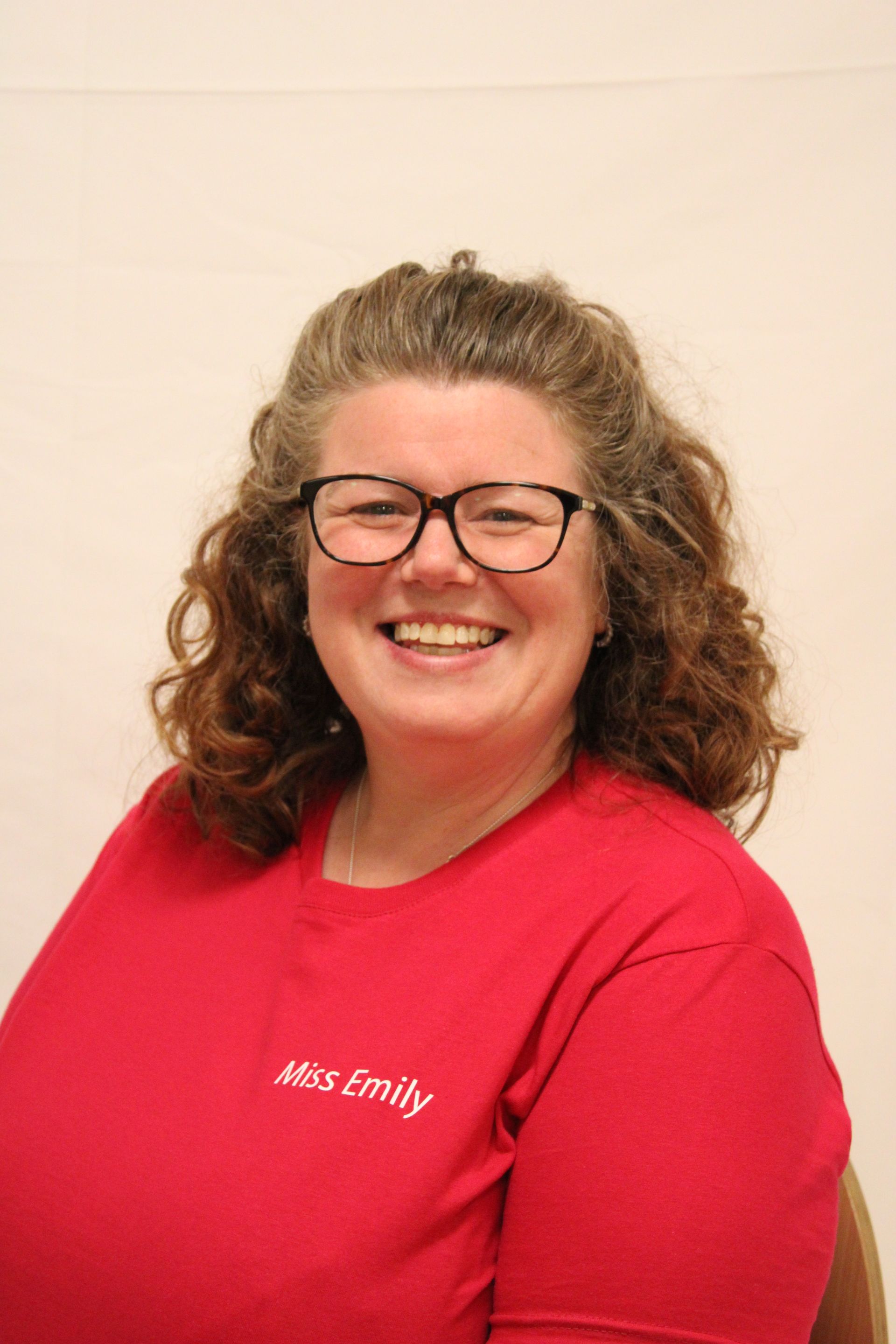 Woman with glasses wearing a red shirt with 
