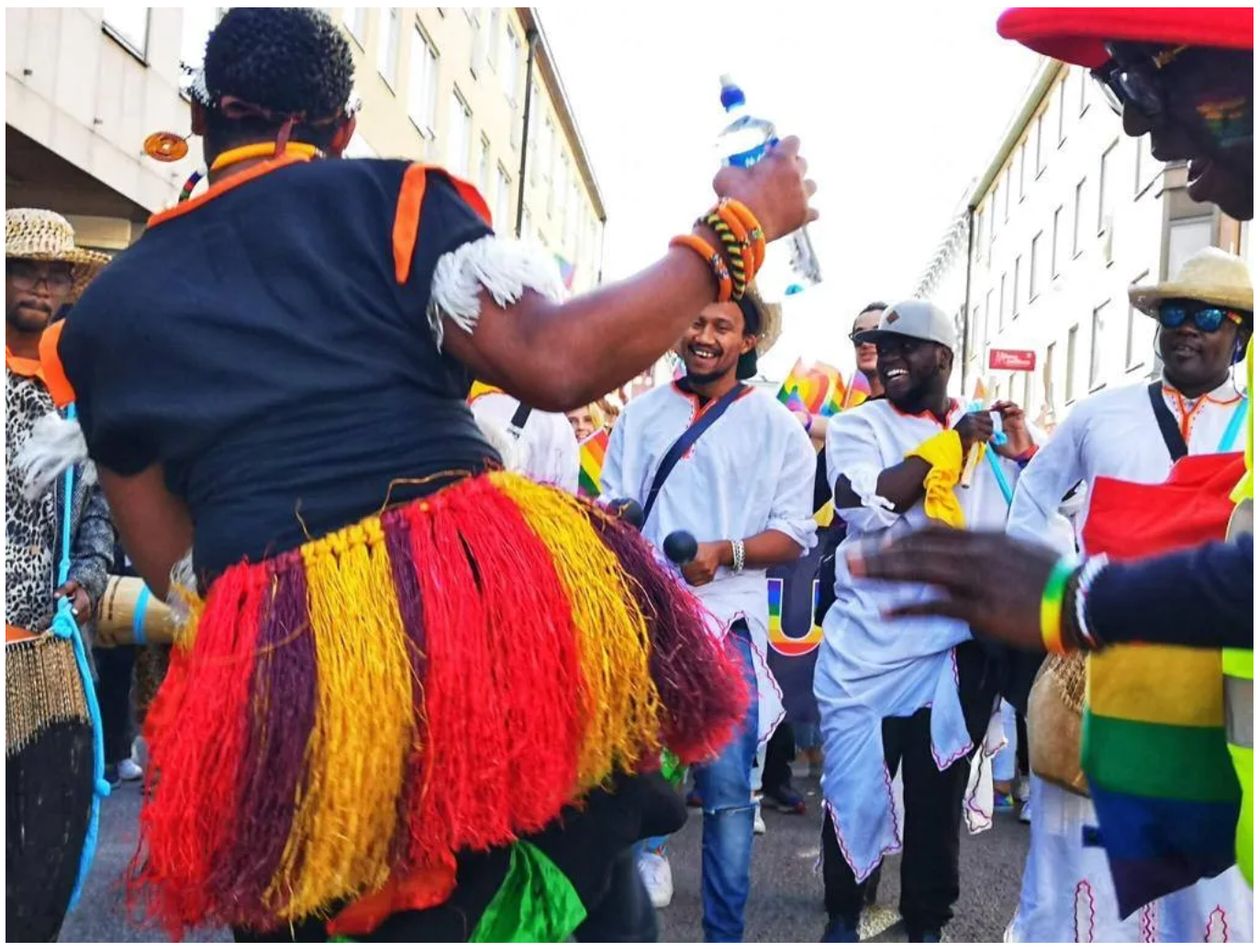 A woman in a colorful skirt is holding a bottle of water