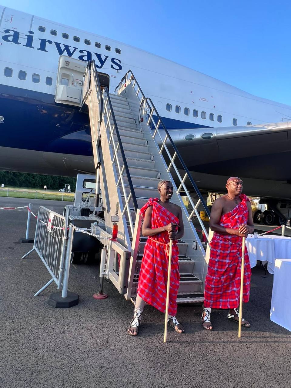 Two men standing in front of an airplane that says airways