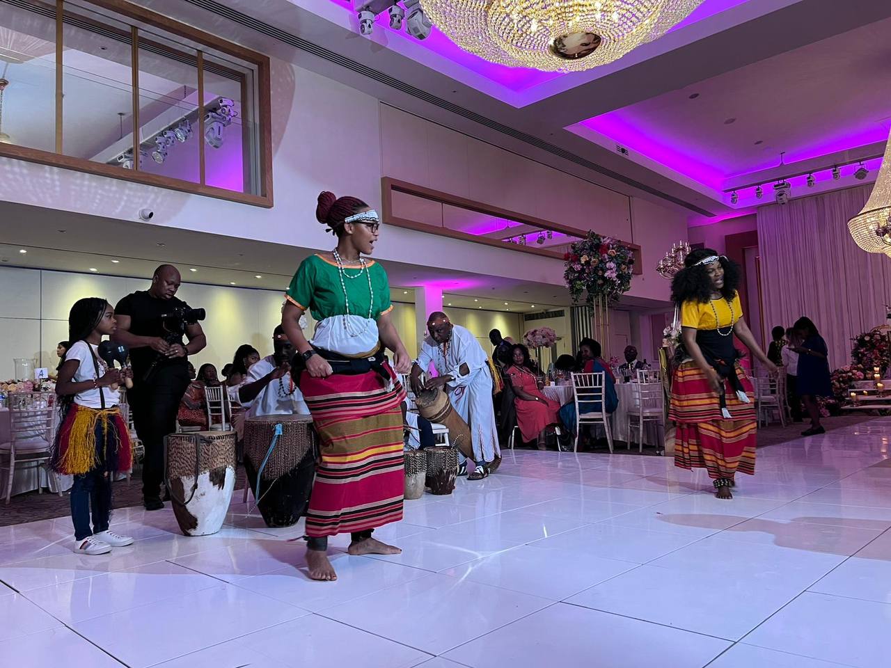 A group of people are dancing in a large room.