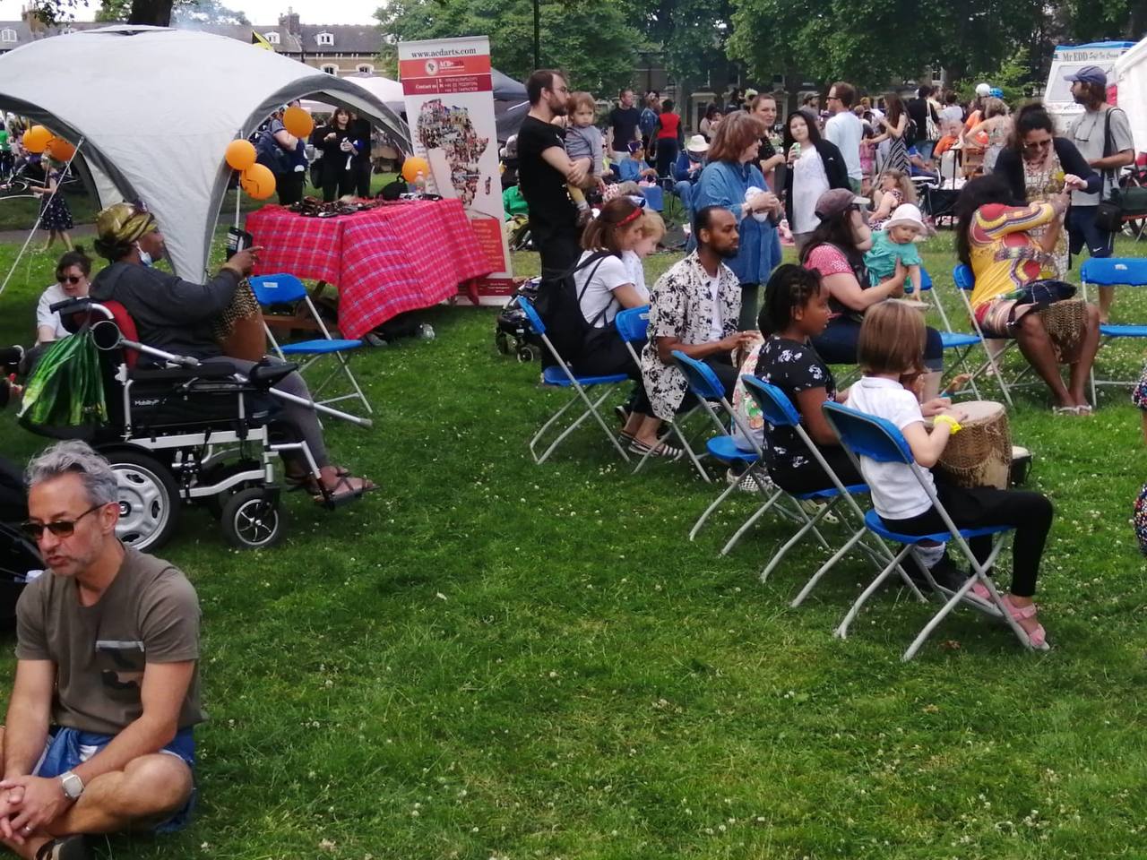 A group of people are sitting in chairs in a park