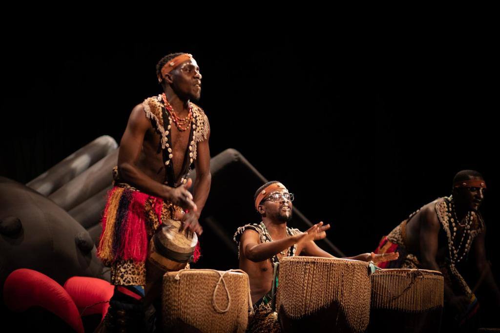 A group of men are playing drums on a stage.