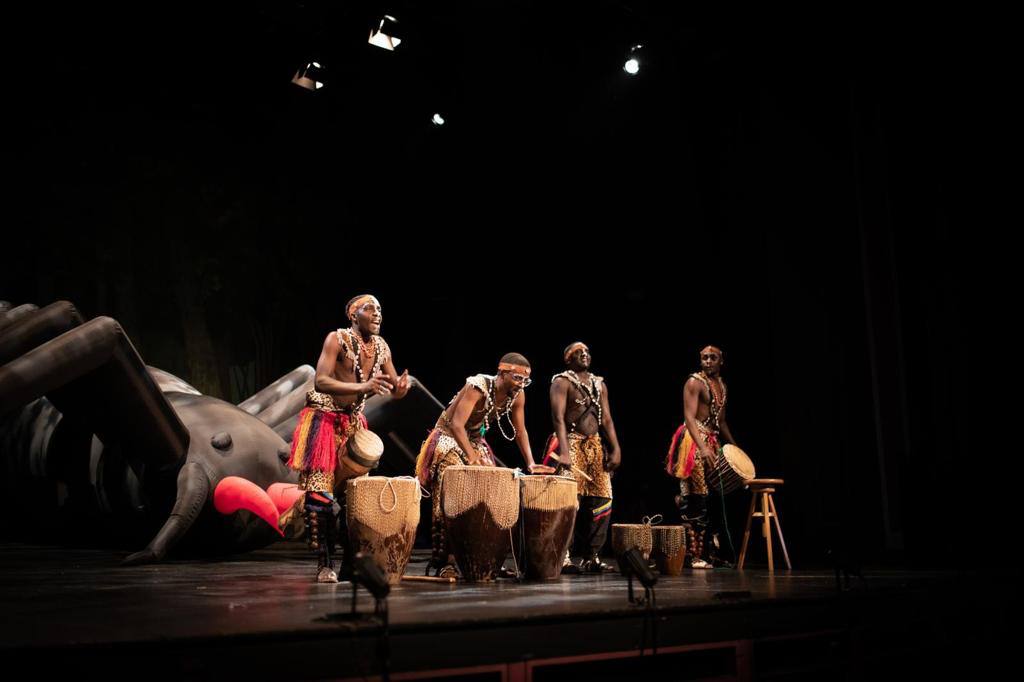 A group of men are playing drums on a stage.