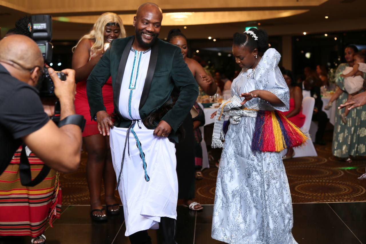 A man is taking a picture of a man and woman dancing on a dance floor.