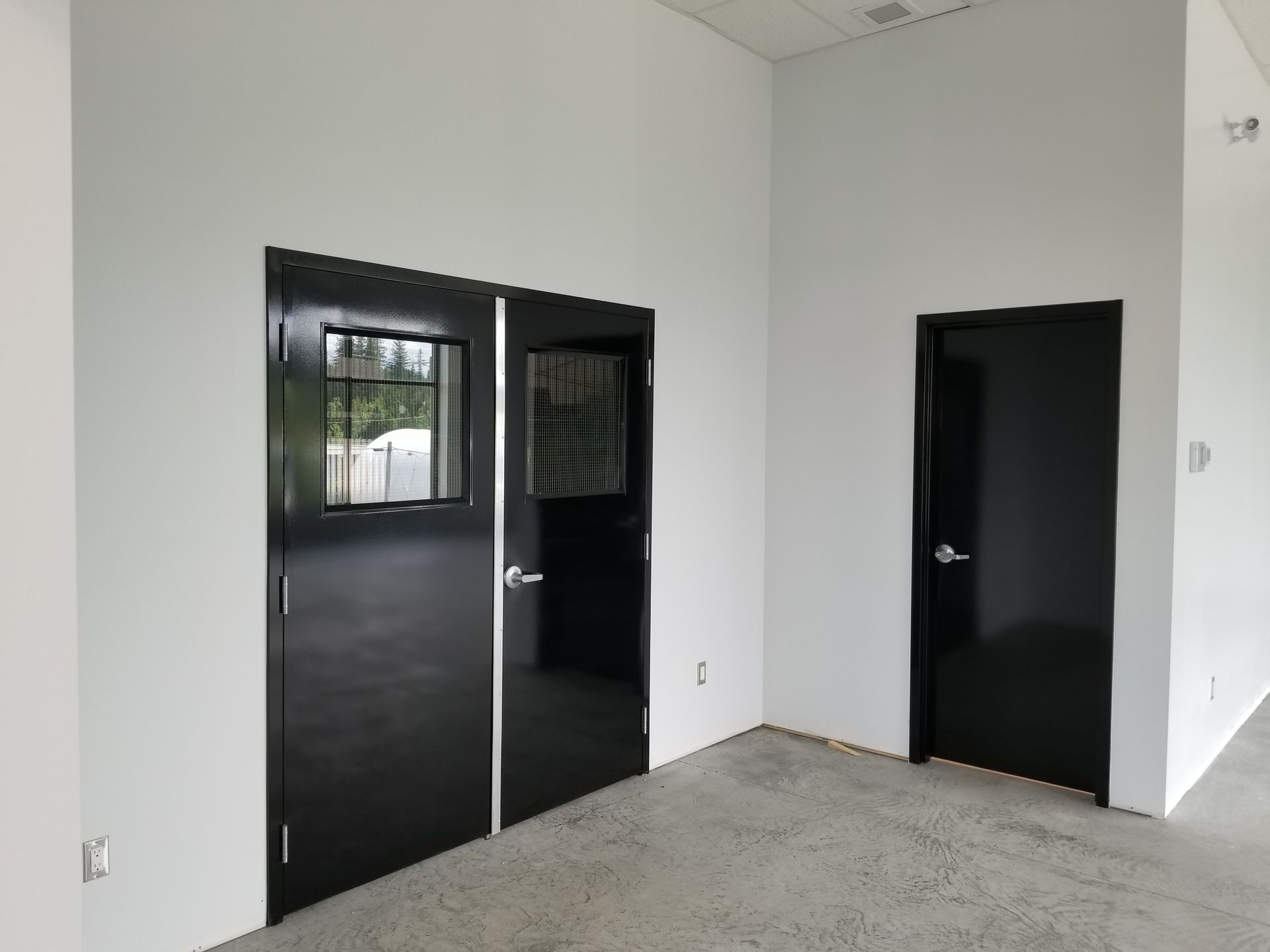 Black metal gate with a white control box and smaller white box.