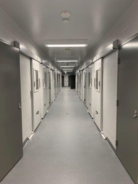 A long hallway with a lot of doors in a hospital.