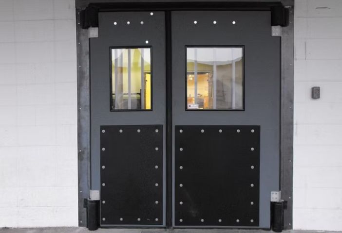 A pair of black doors with a white wall behind them